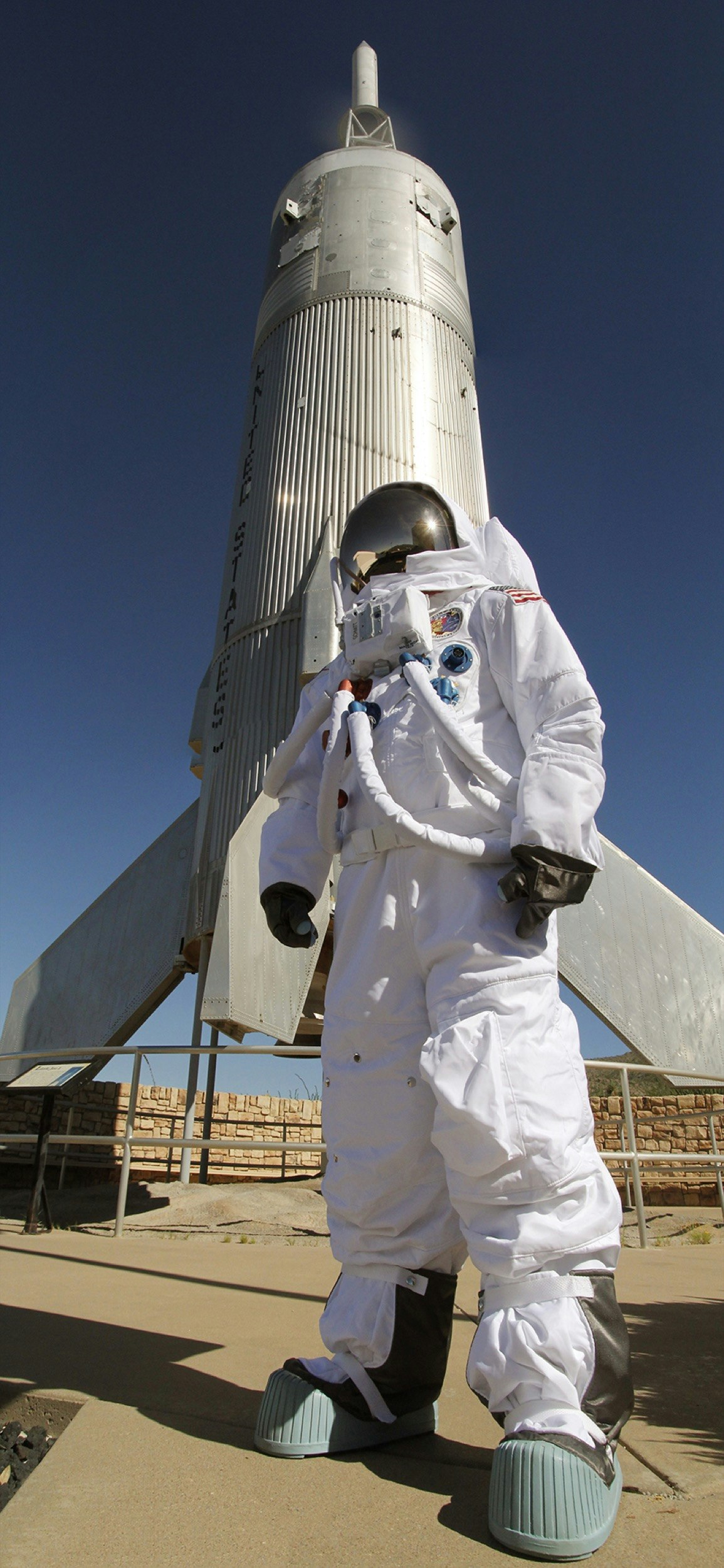 A space suit and rocket are seen in an outdoor exhibit at the New Mexico Museum of Space History