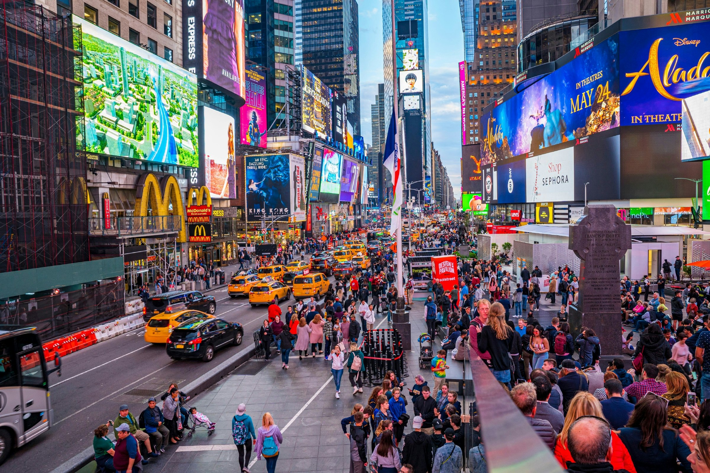 New York City’s Times Square, crowded in the early evening with pedestrians and traffic.