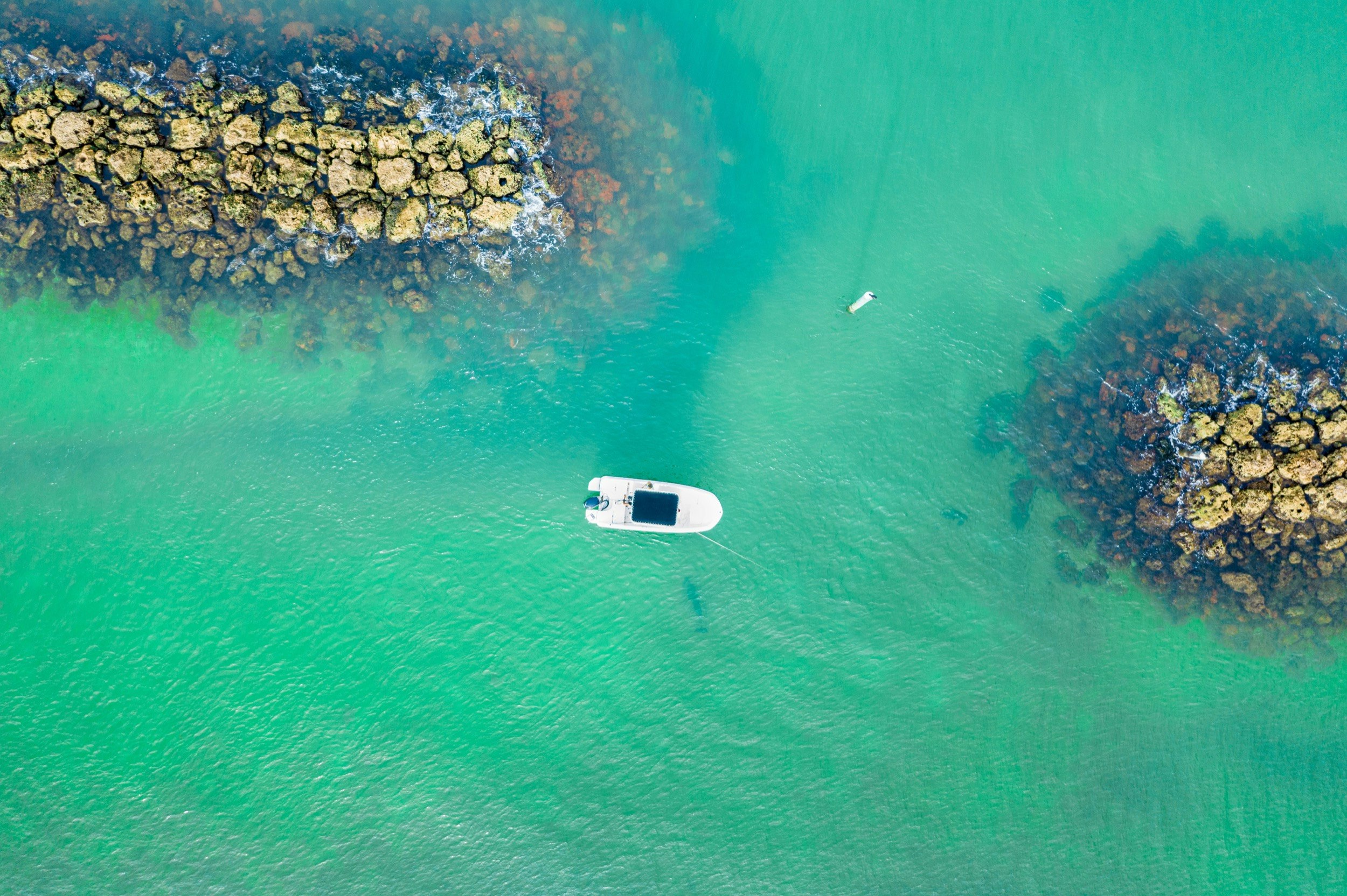 Looking down from above on a small motorboat exploring several rocky islands in southwest Florida