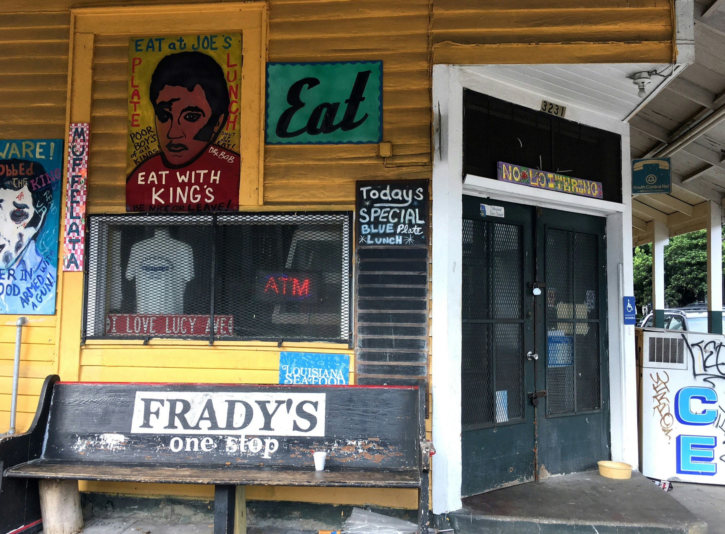 En gul byggnad har massor av målade skyltar och graffiti i New Orleans