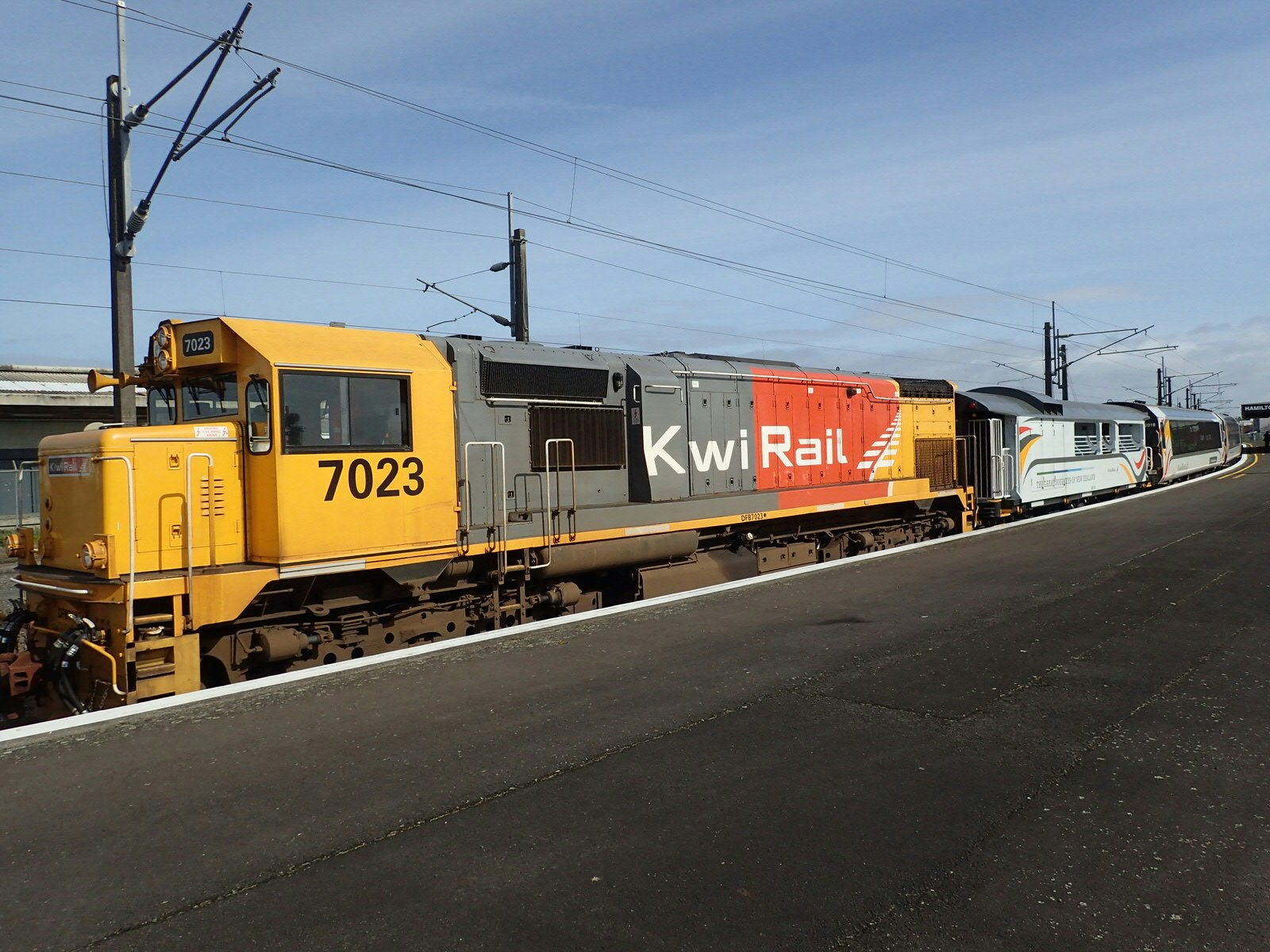 The yellow, black and red Northern Explorer train at Hamilton station, New Zealand.