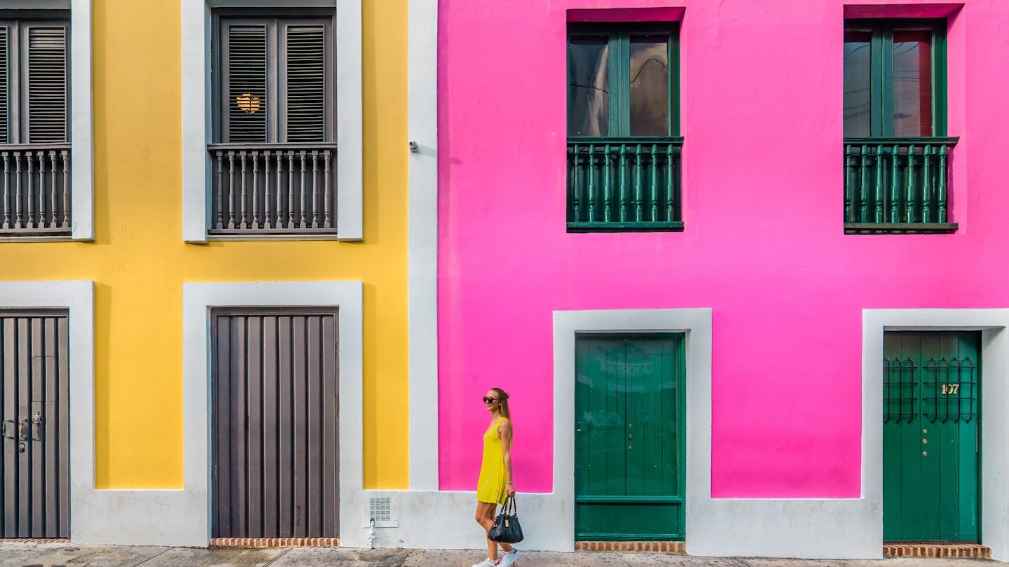 Woman in a yellow dress in front of Colourful facades in Old San Juan, Puerto Rico 