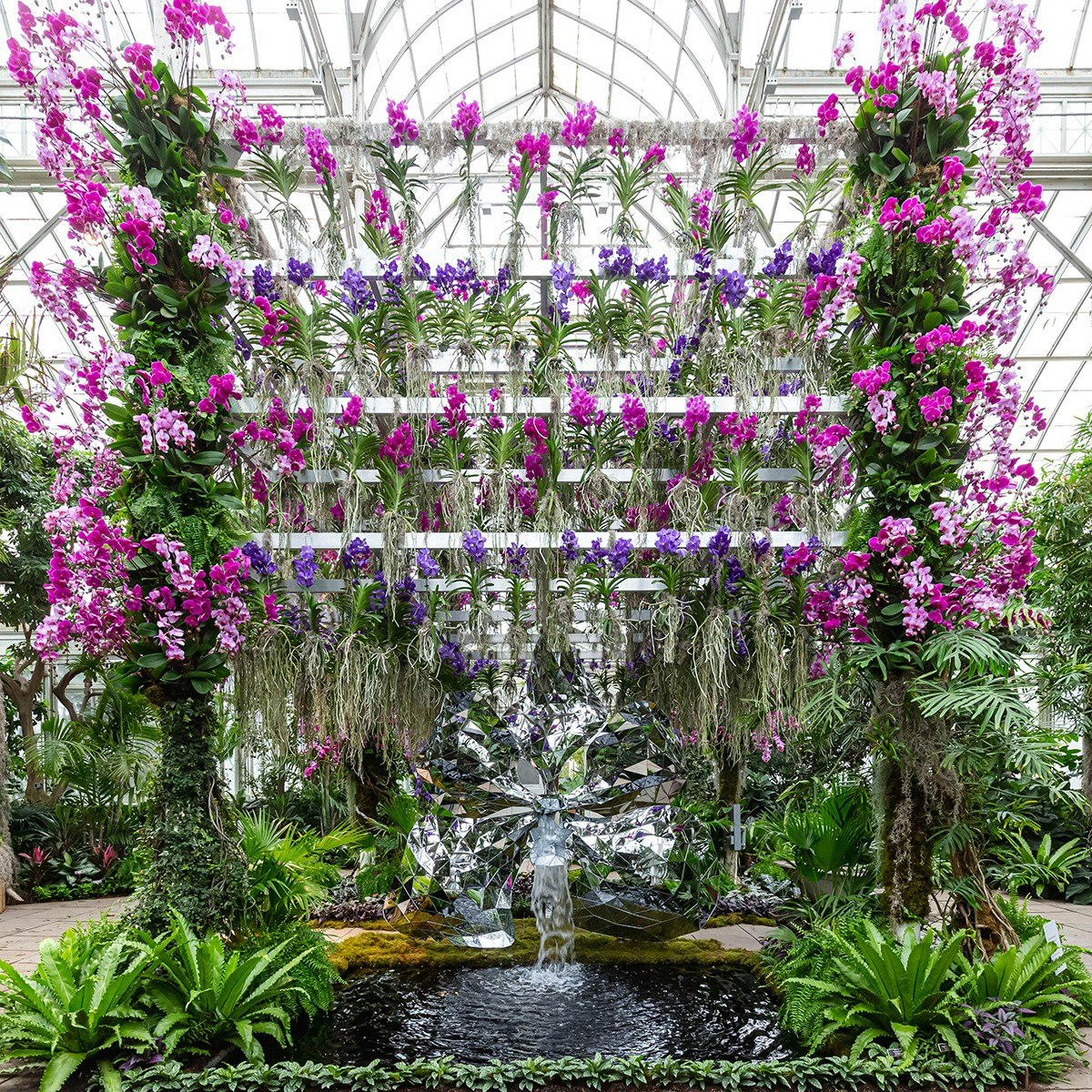 Purple vandas suspended above a 10-foot-tall mirrored orchid sculpture
