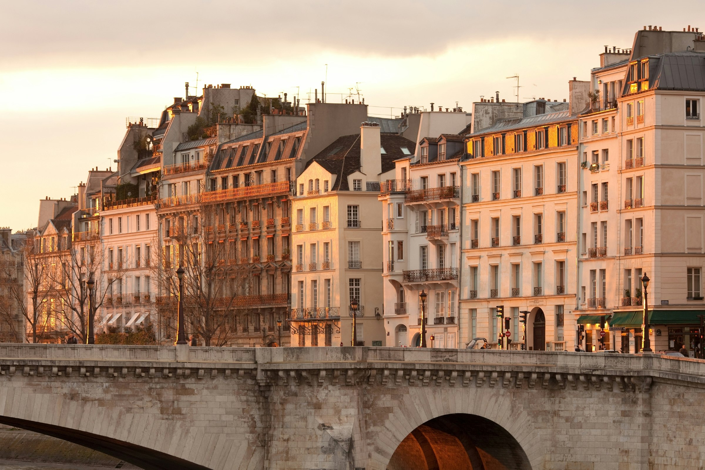 Facades of apartment buildings at Ile Saint Louis and Pont de la Tournelle bridge, Paris, France.