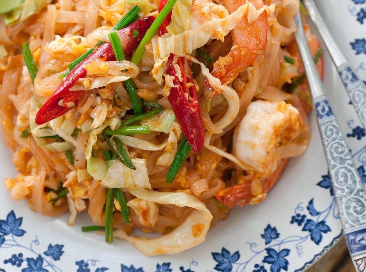 A portion of phat thai as viewed from directly above. The dish consists of noodles, prawns and vegetables.