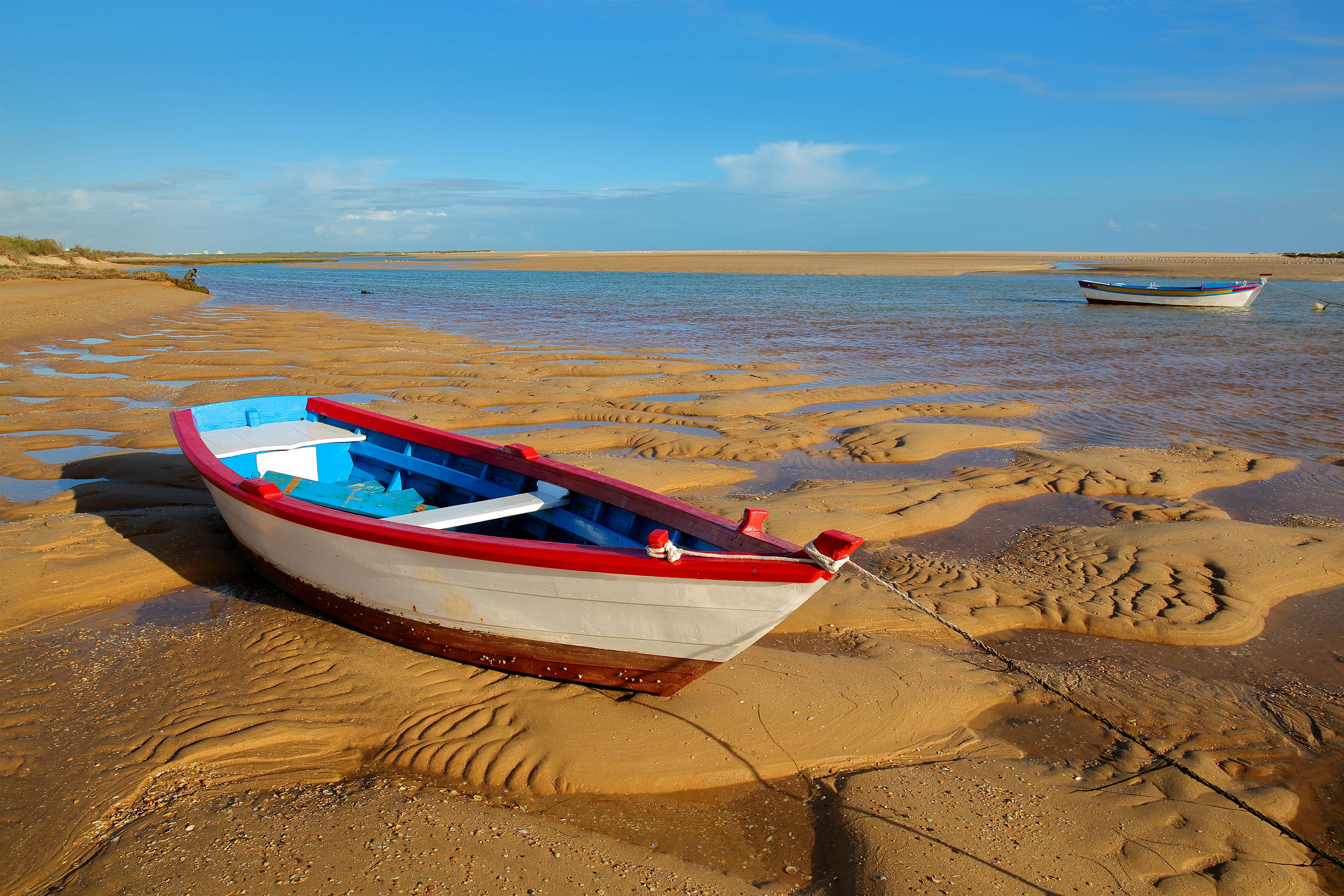 Praia de Cacela Velha.jpg A red, white and blue boat sits beached on sand near water