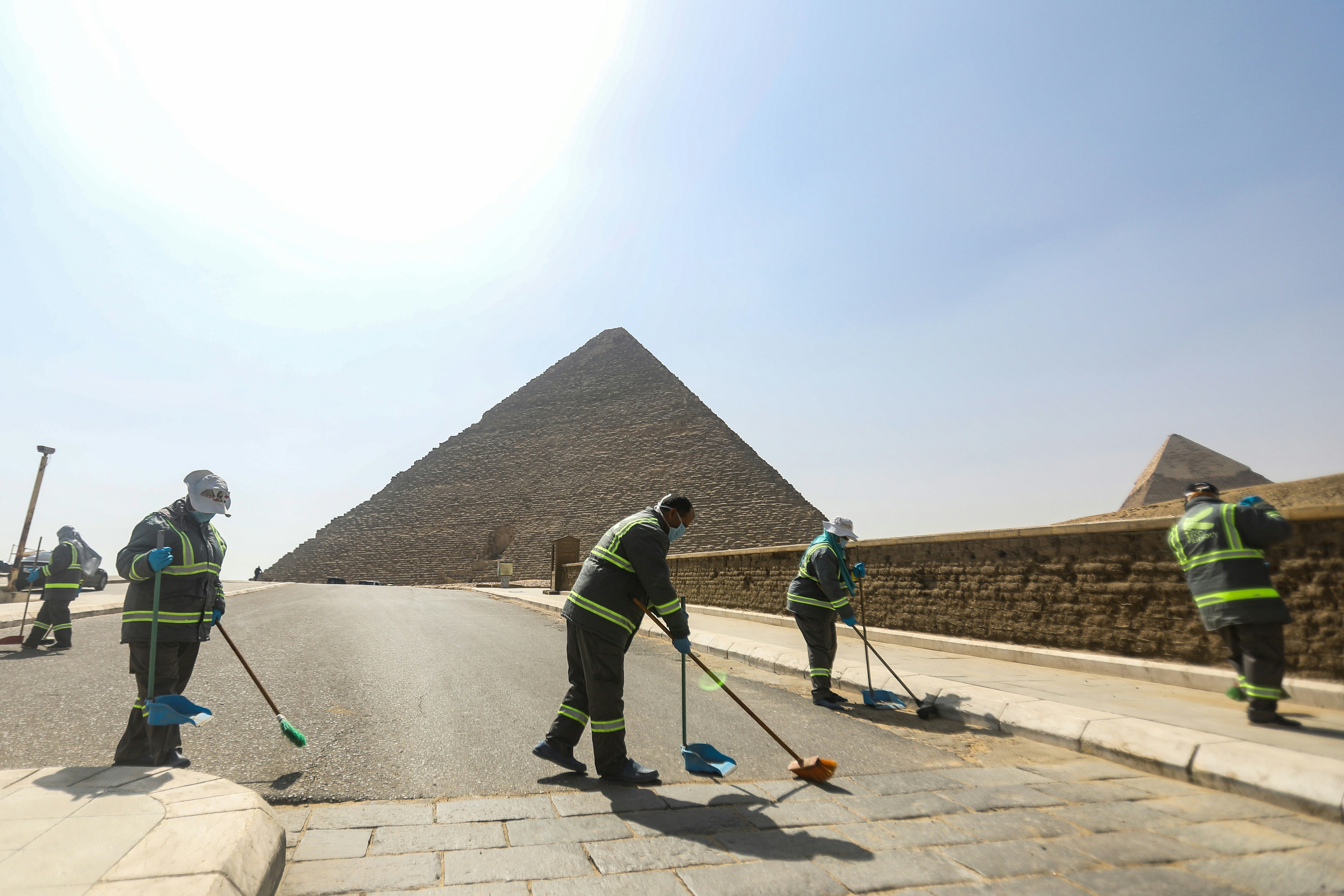 : Workers take part in a cleaning and disinfection process at the Giza Plateau