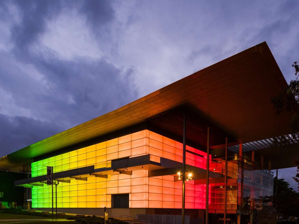Brisbane's Gallery of Modern Art for Culture and Street are at dusk. The building's exterior is made up of multicoloured light boxes