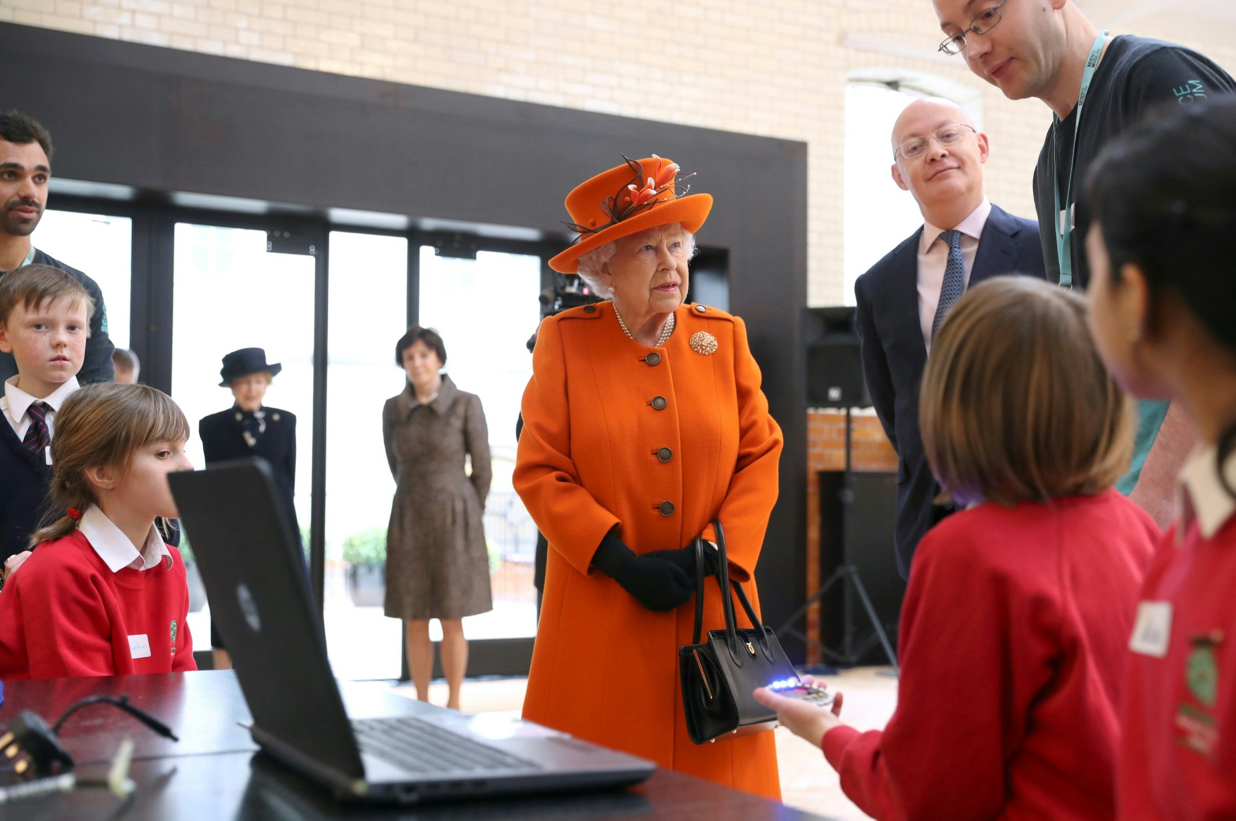 Queen Elizabeth II speaks with children about computer programming during a visit to the Science Museum