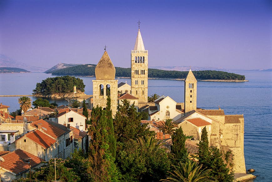 The historic spires of Rab at sunset, backed by the Kvarner Gulf.