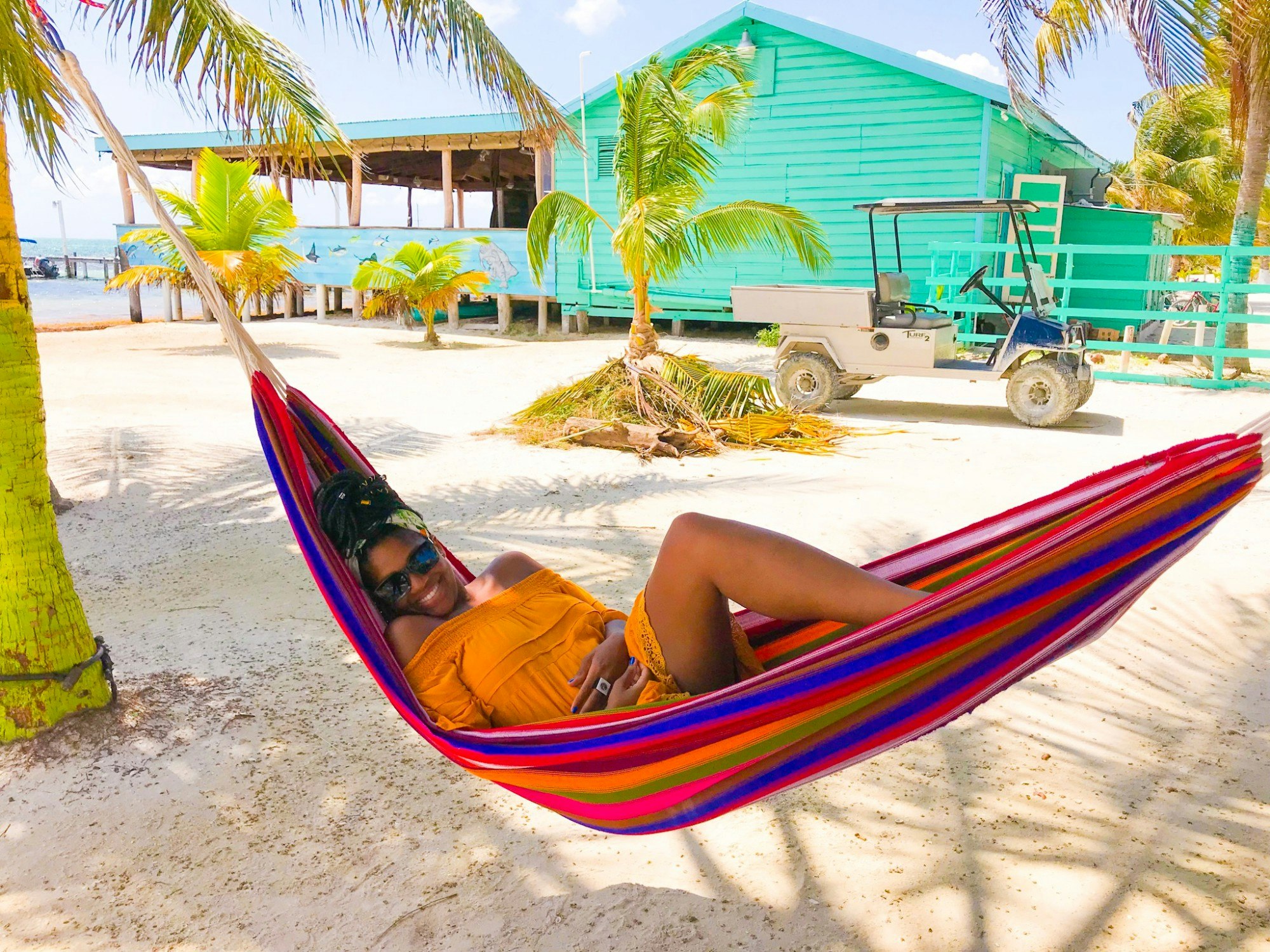 Rachel relaxes in a multi-coloured hammock on a white sandy beach