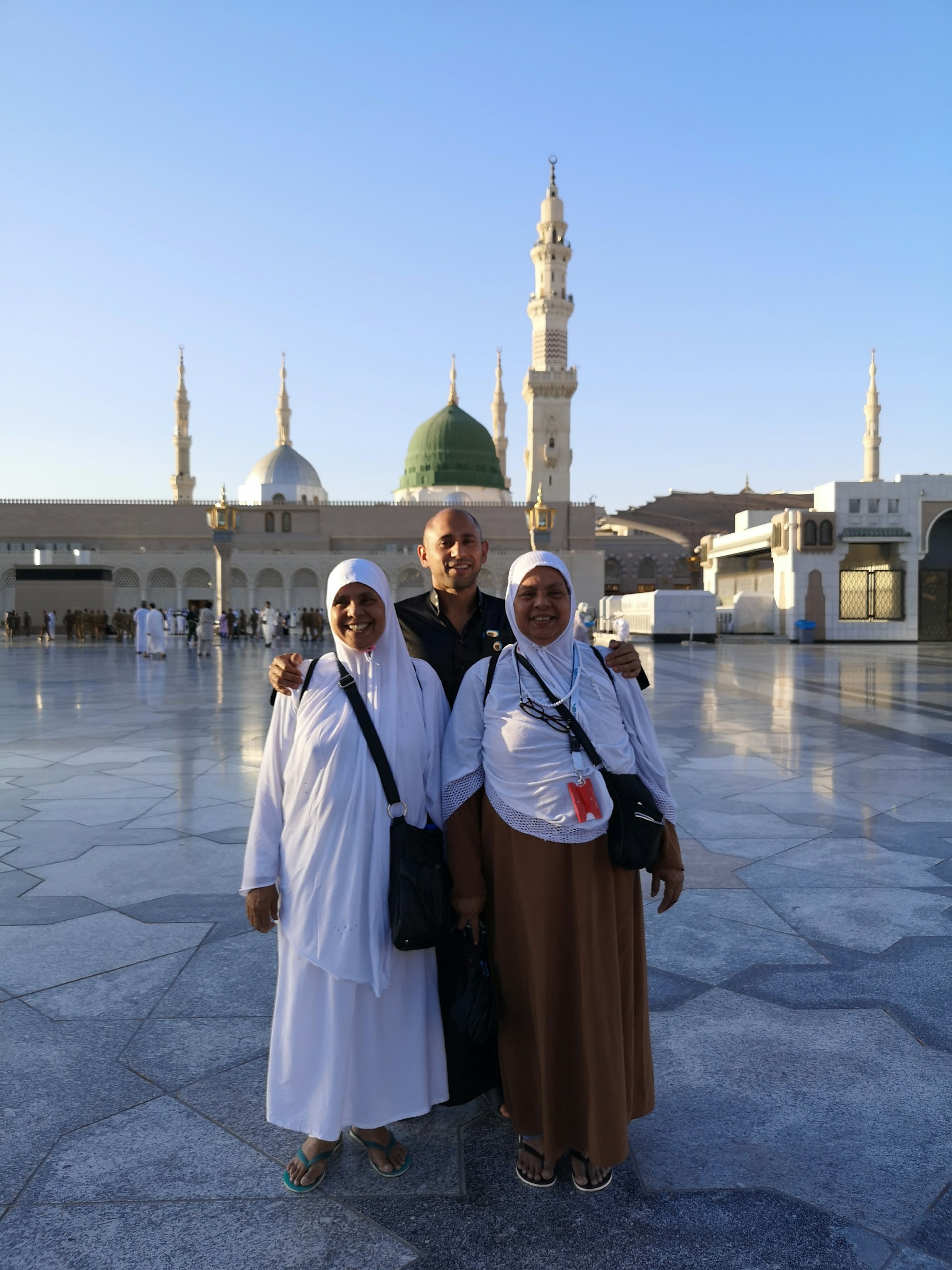 Rafique stands with his mother and aunt in front of the mosque in Madinah