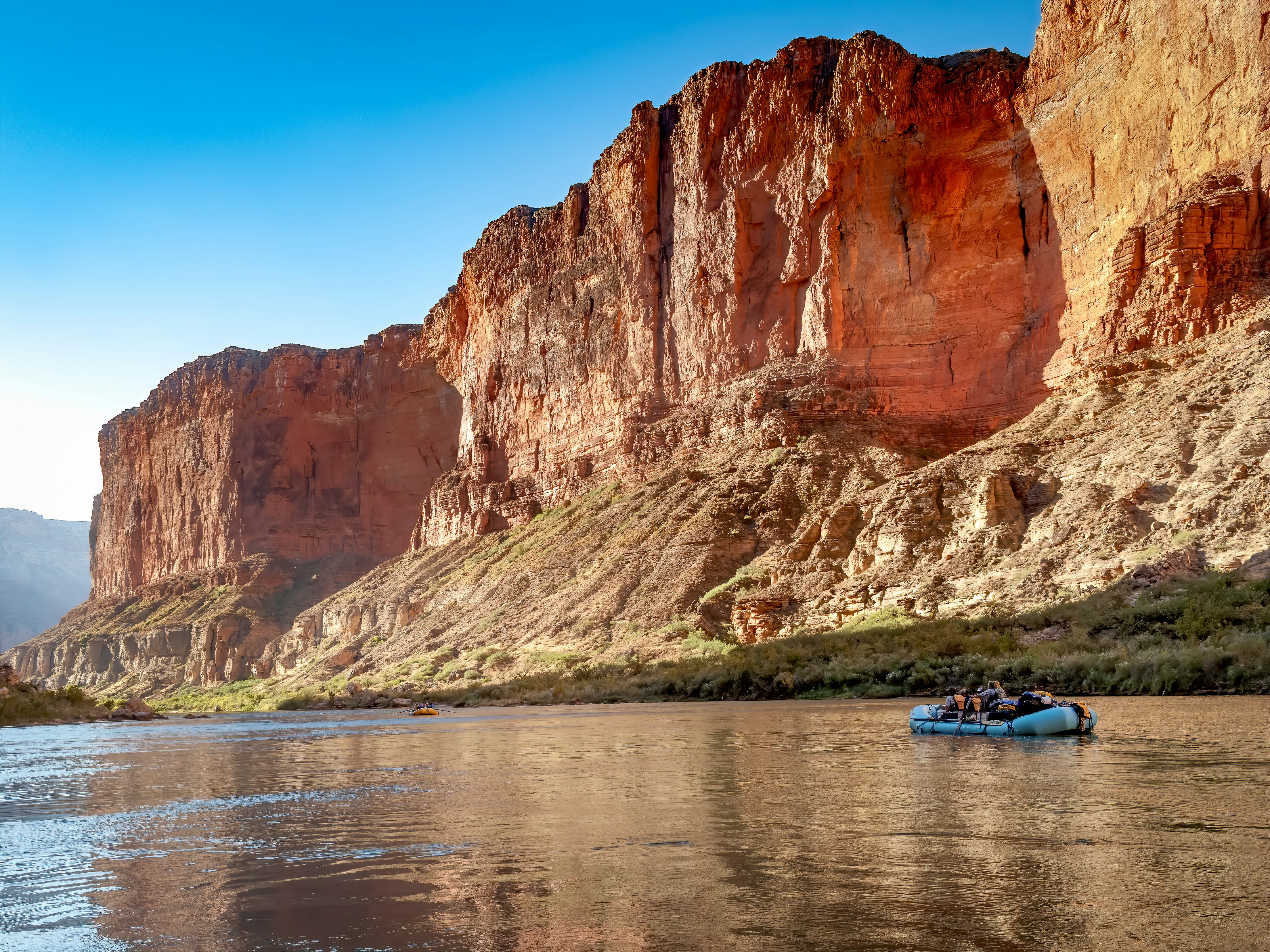 Raft floats down river through Grand Canyon