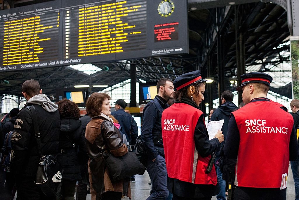 Staff of the SNCF help people with information about train schedules