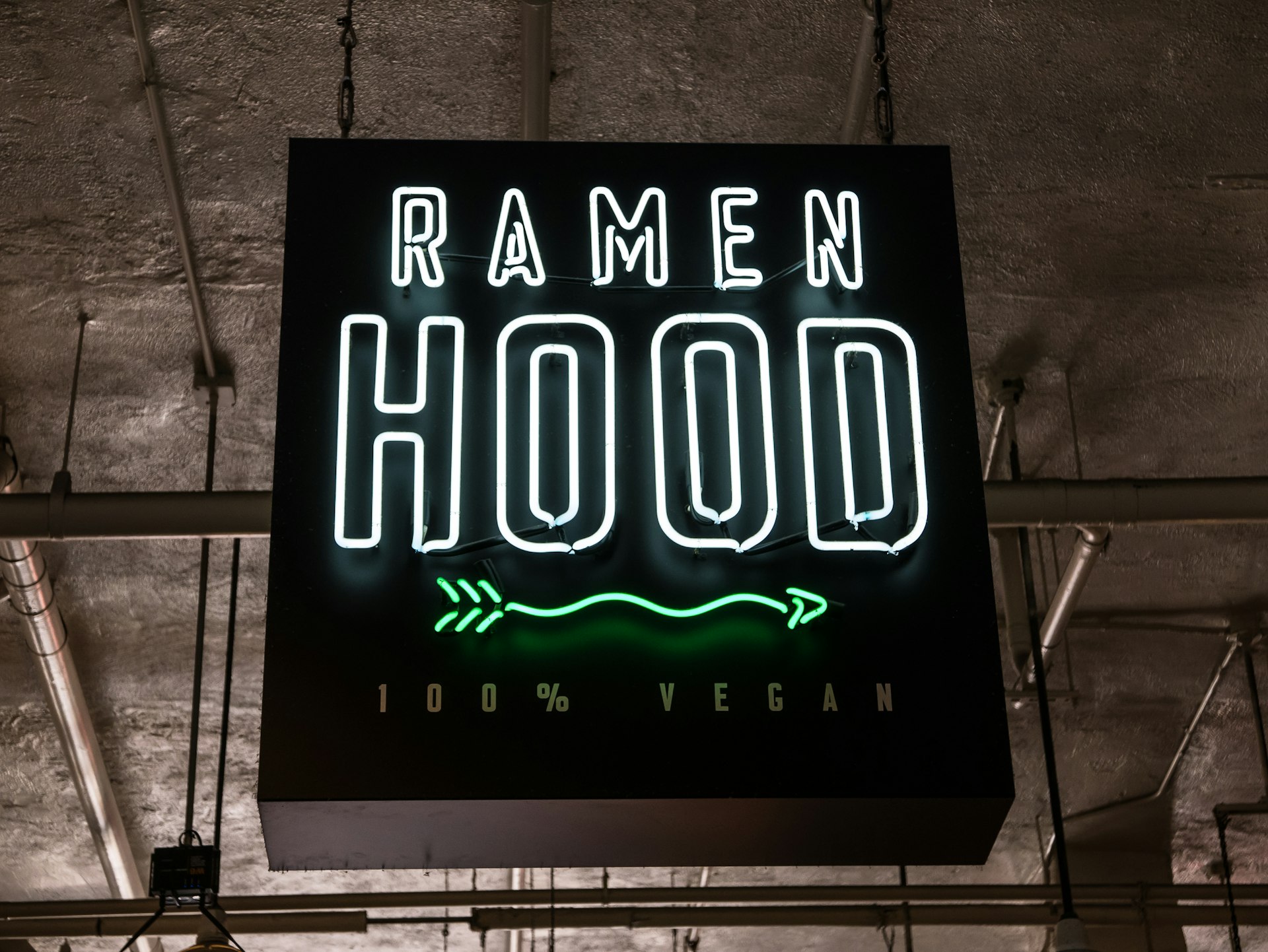 Neon sign with the words 'Ramen Hood' hangs from a ceiling; LA vegan restaurants 