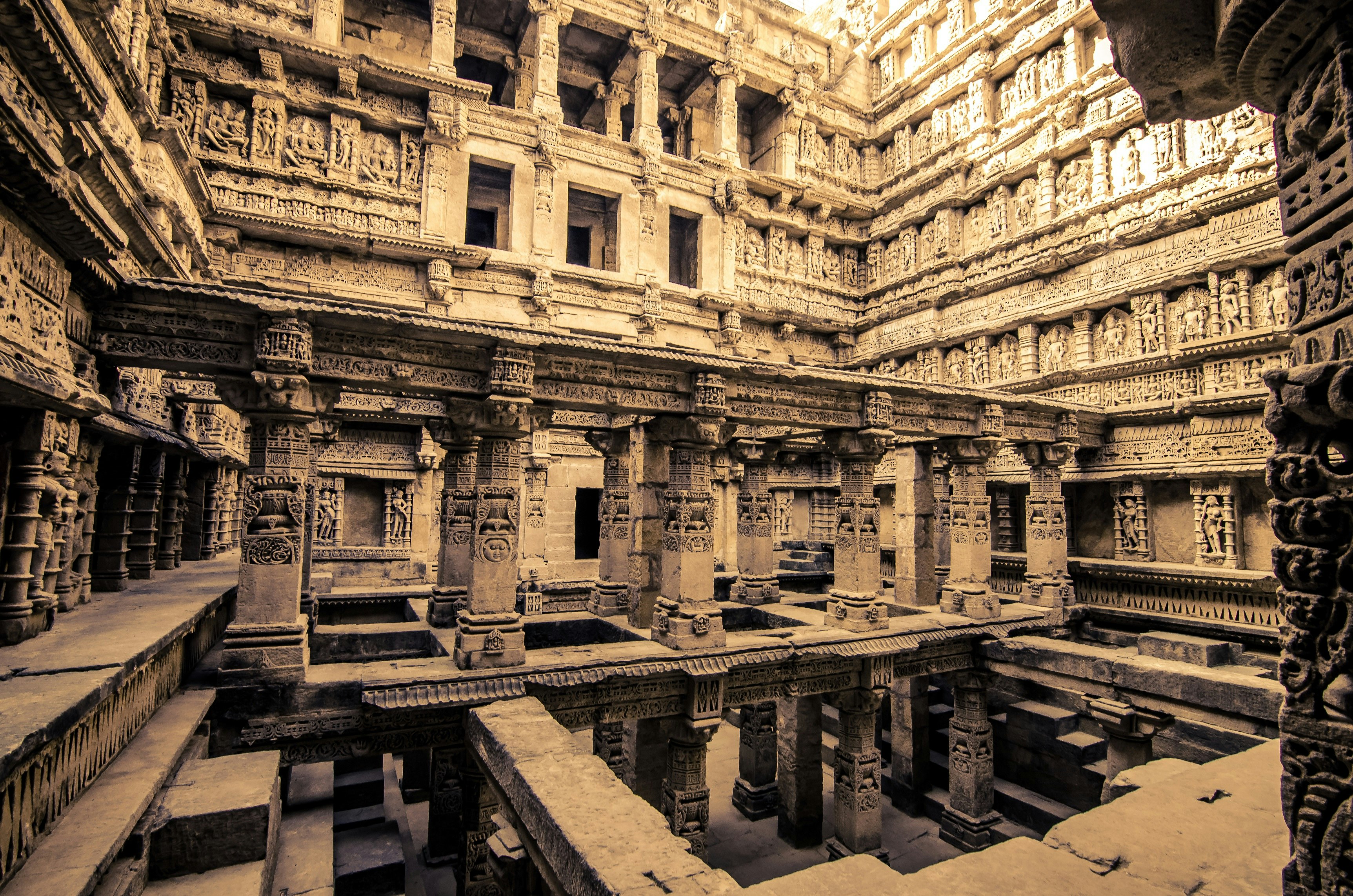 The interior of Rani-ki-Vav stepwell in Gujarat. The stone walls and pillars on the inside of the stepwell are covered in carvings of religious deities.