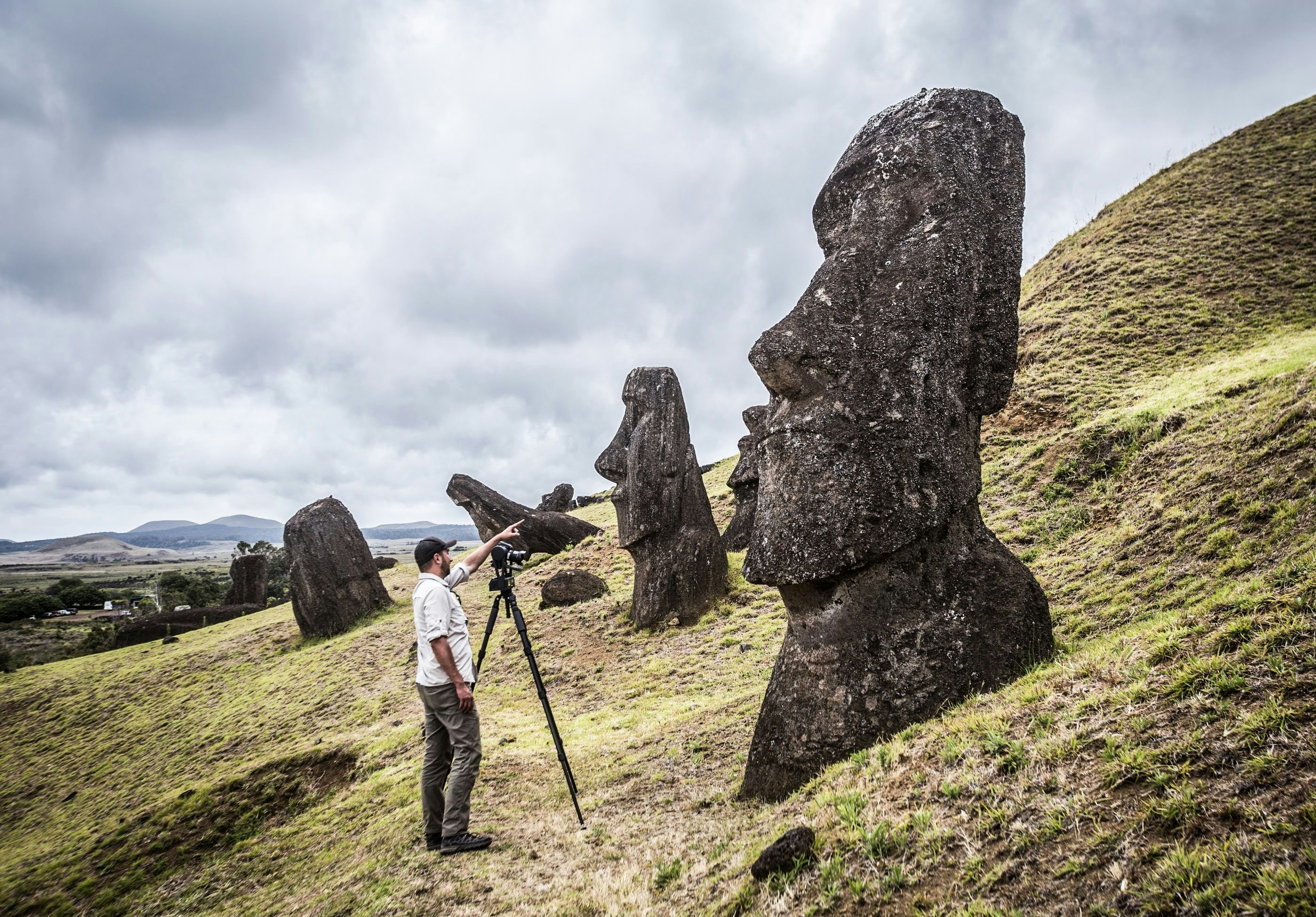 A surveyor in front of an Easter Island statue