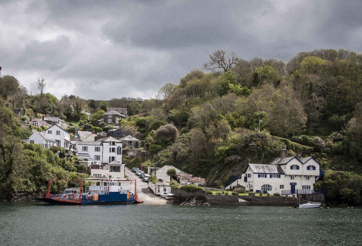 A ferry is going down the river Fowey. Ferryside, the home of author Daphne du Maurier, is visible.