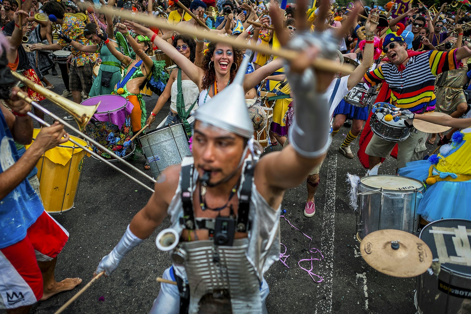 A man in a Tin Man outfit leads a group of partiers through the streets of Rio during Carnival