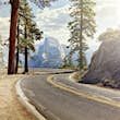 A road winds through Yosemite National Park with the half dome in the background