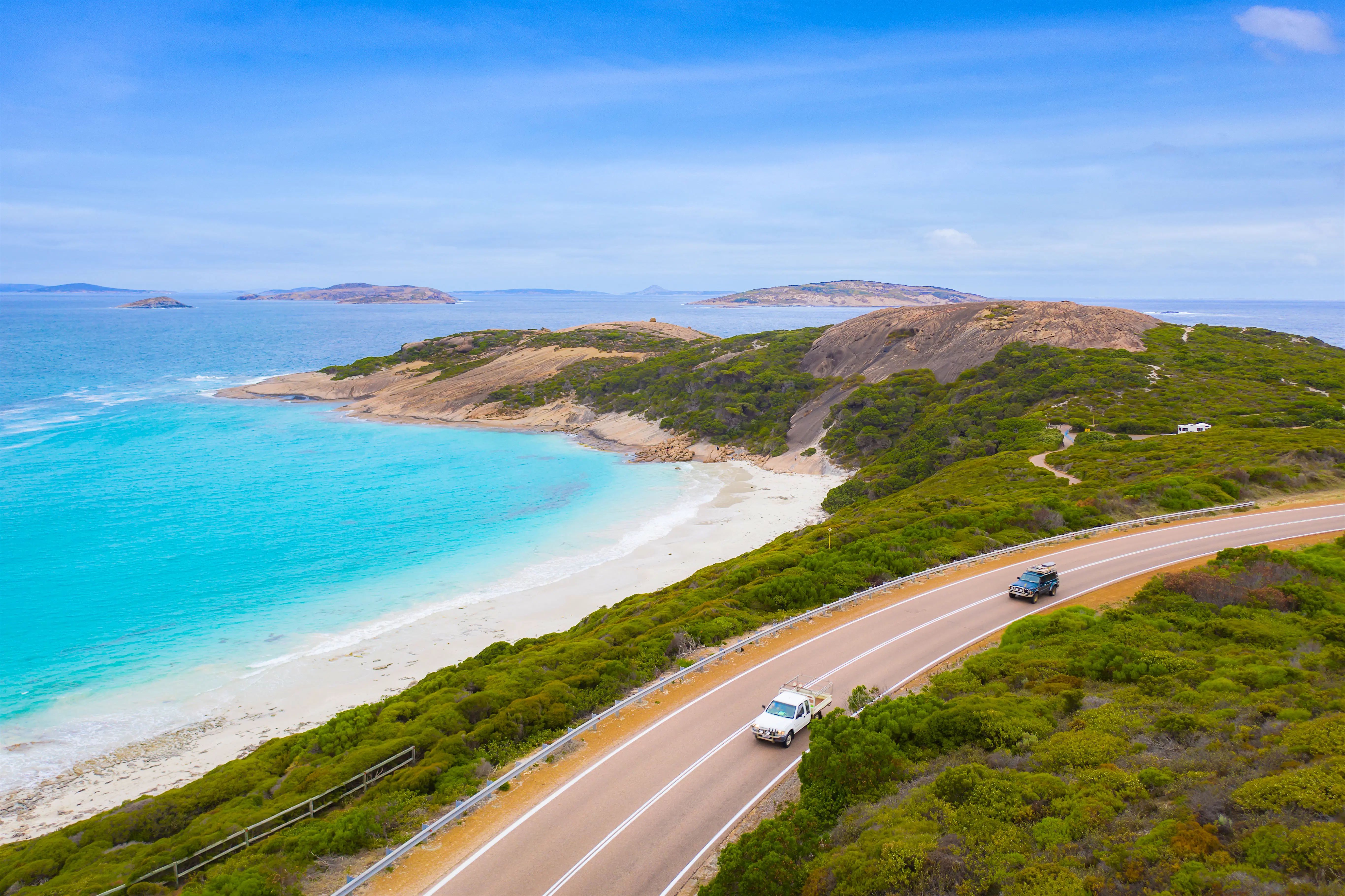 Road trip.jpg Cars drive down an Australian coastal road.