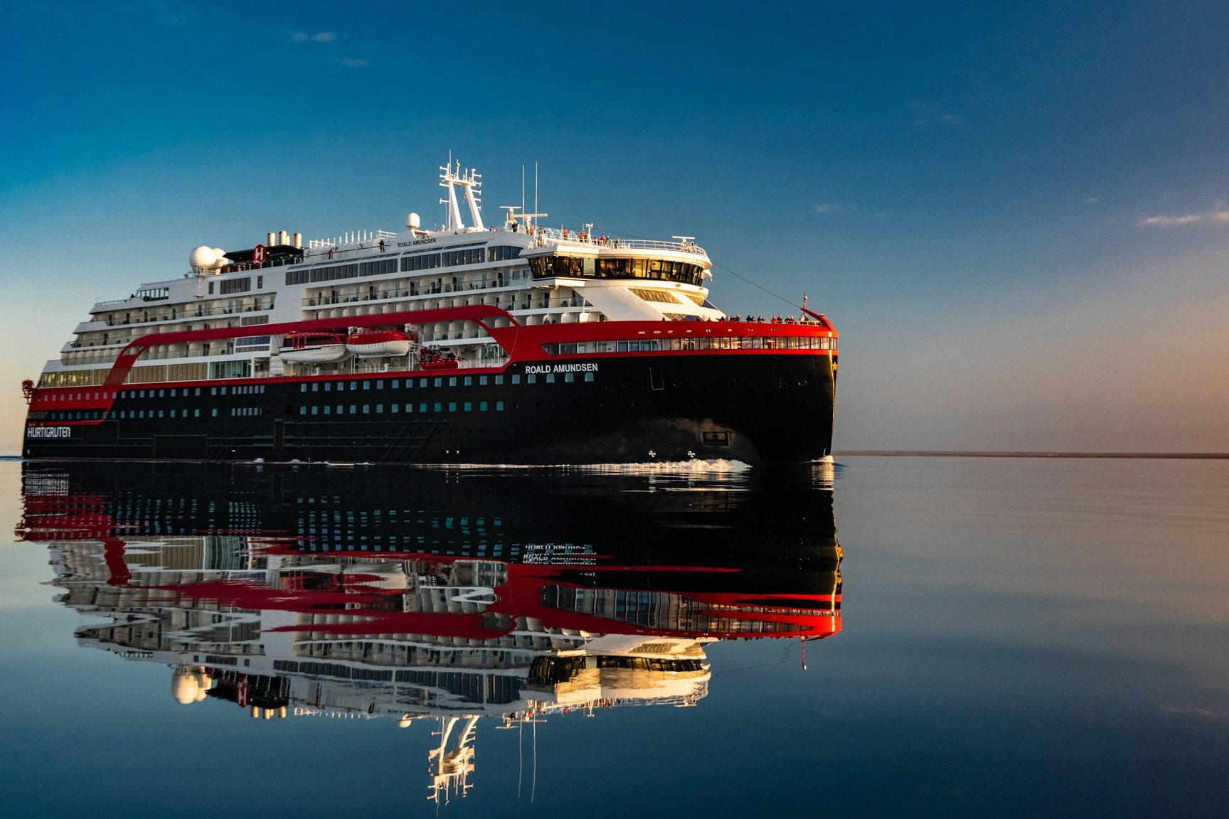 The Roald Amundsen ship on water with its image reflected in the water