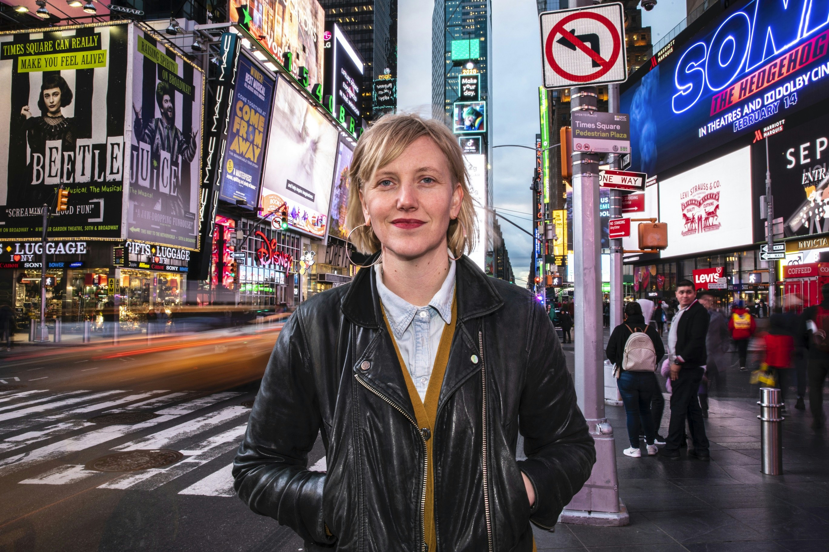 Artist Robin Frohardt standing in Times Square at night