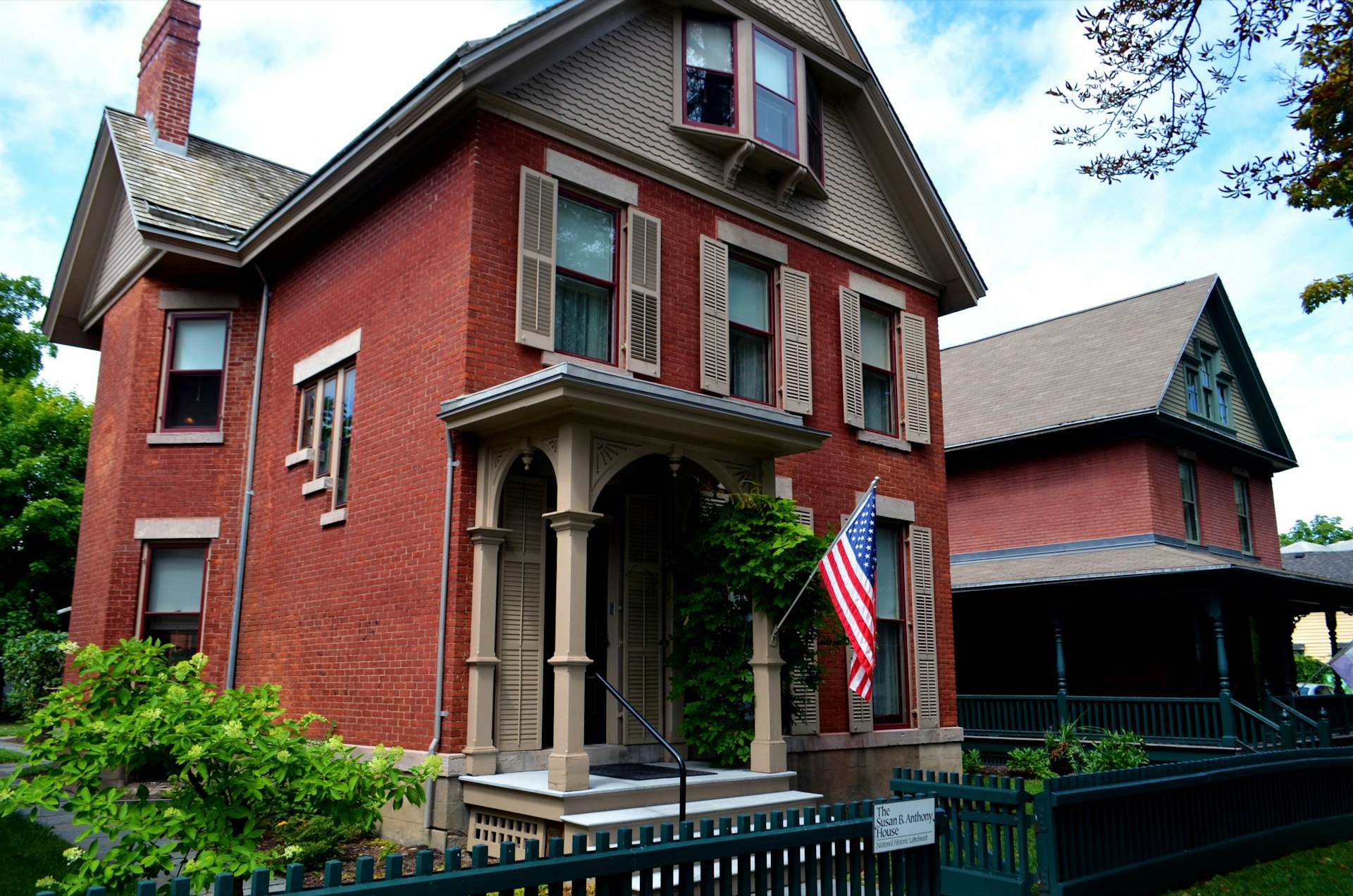 A red brick house with an American flag and a sign saying it's Susan B. Anthony's house in Rochester, New York