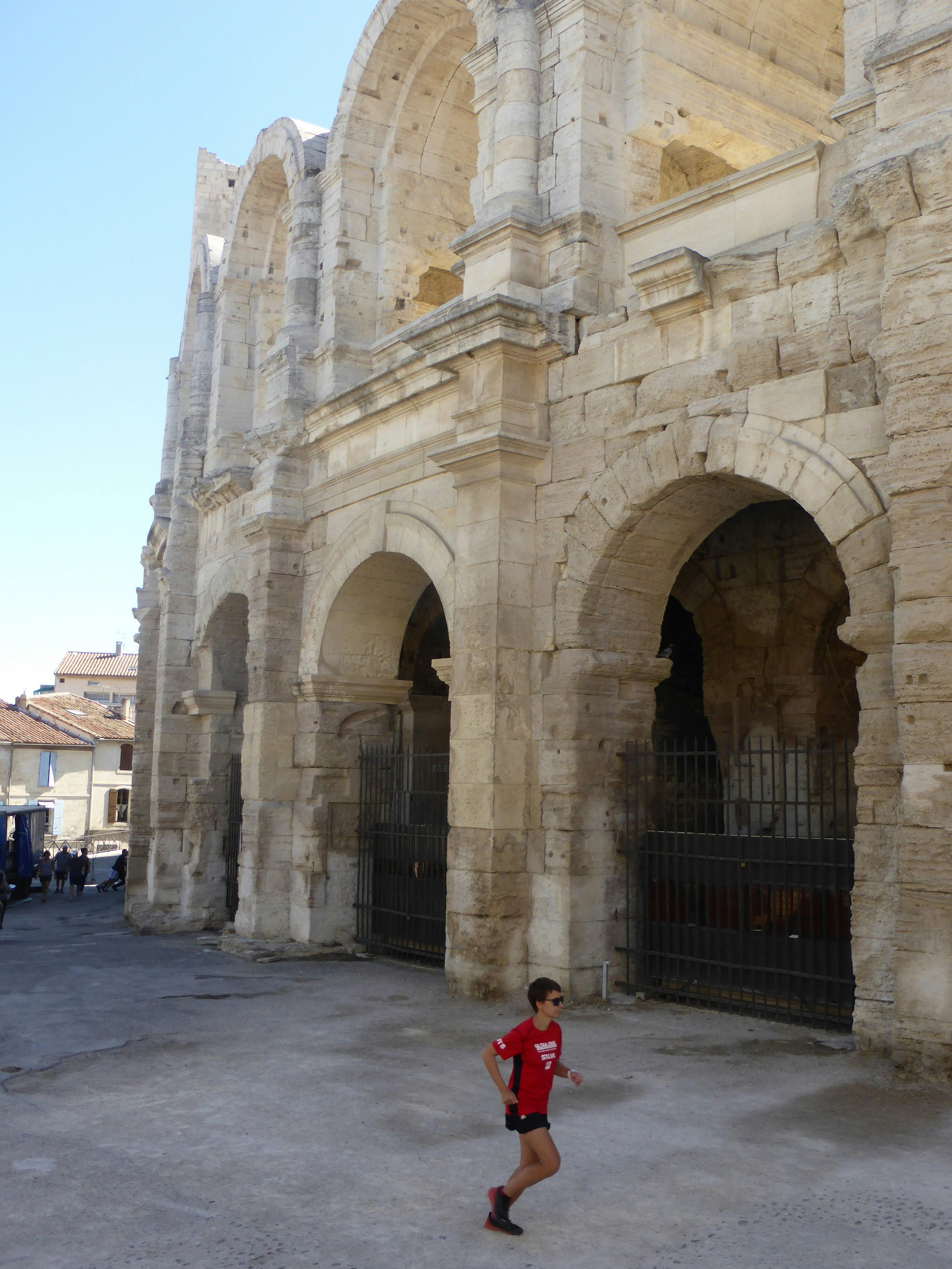 Alecsa running past the Roman amphitheatre in Arles; it's golden stone resembles the Colosseum in Rome.