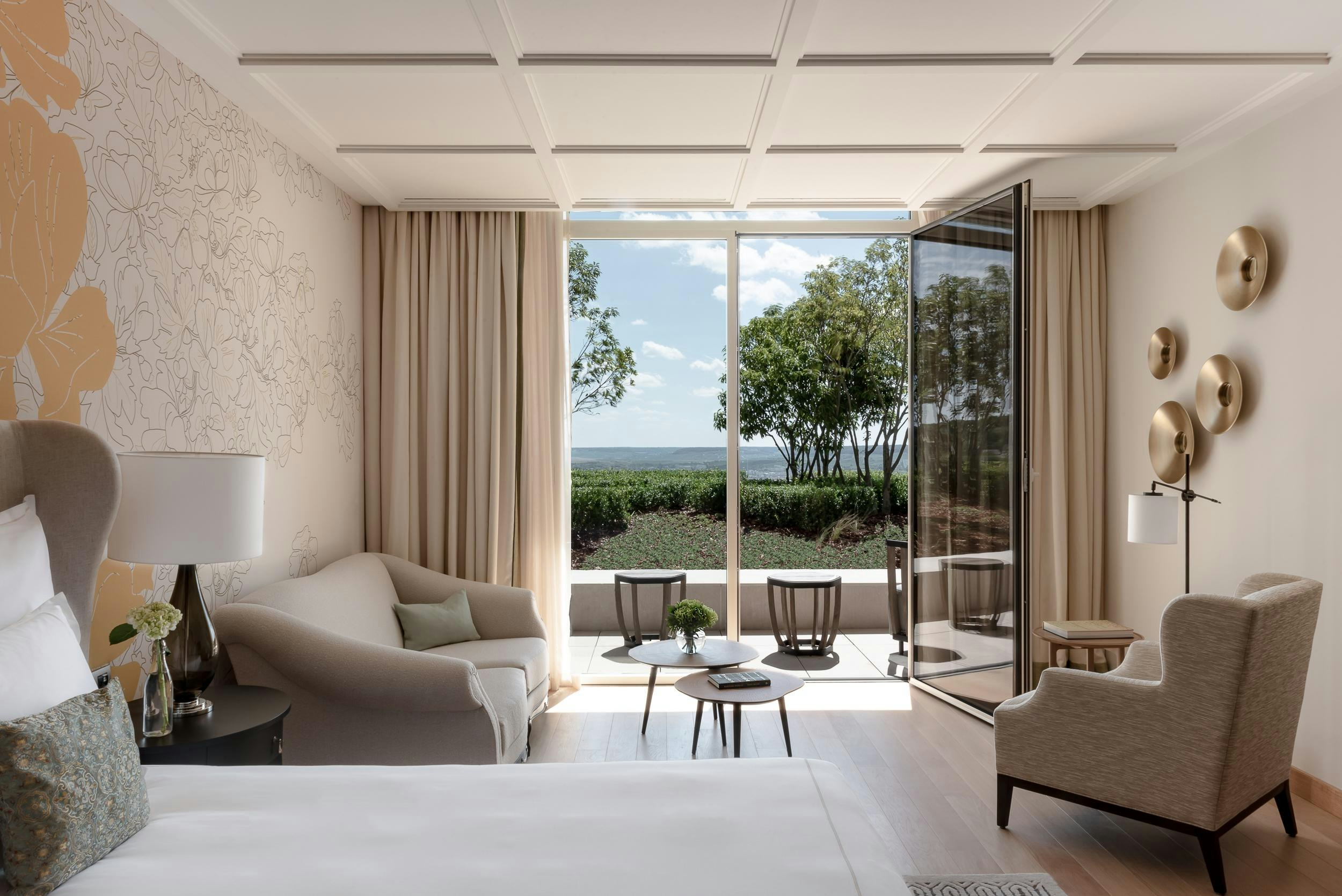 Luxurious hotel room with a balcony and view of vineyards.jpg