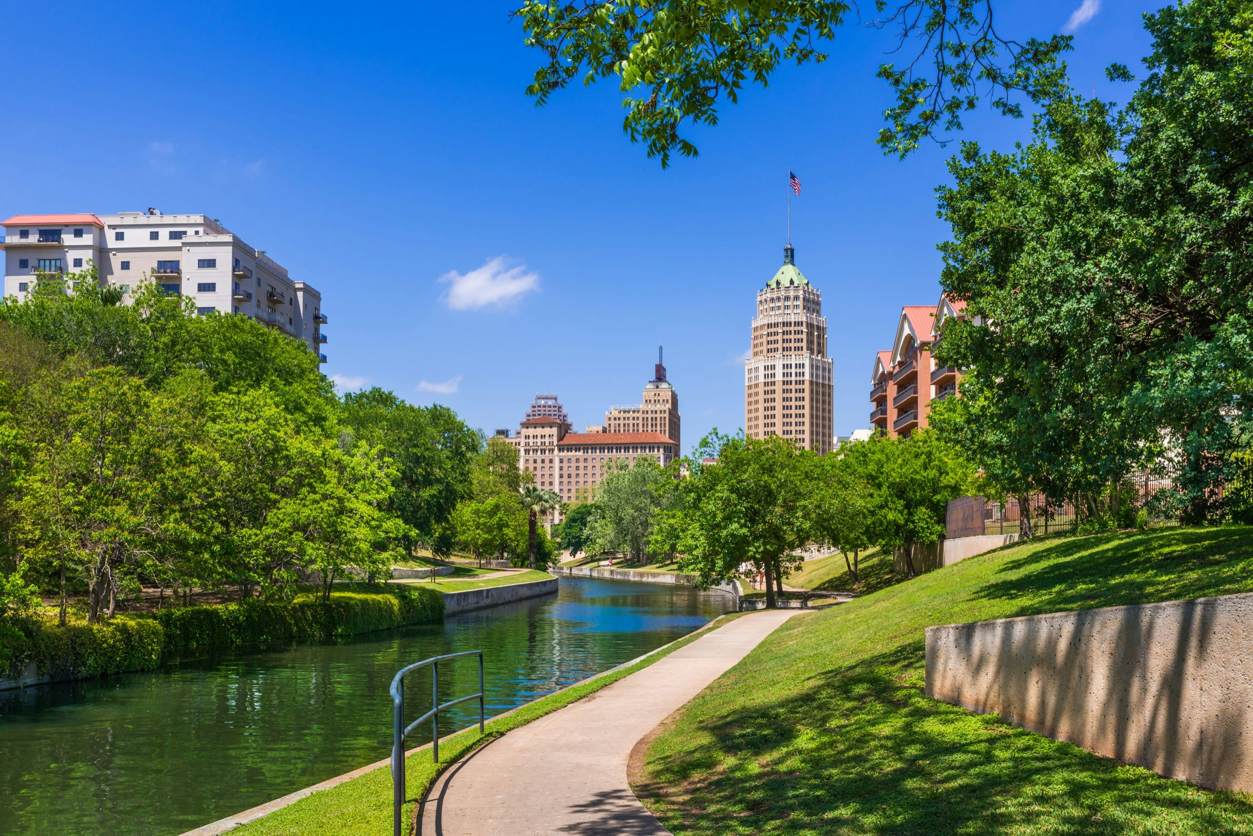 The San Antonio skyline rises above the river and manicured trails outside the downtown core