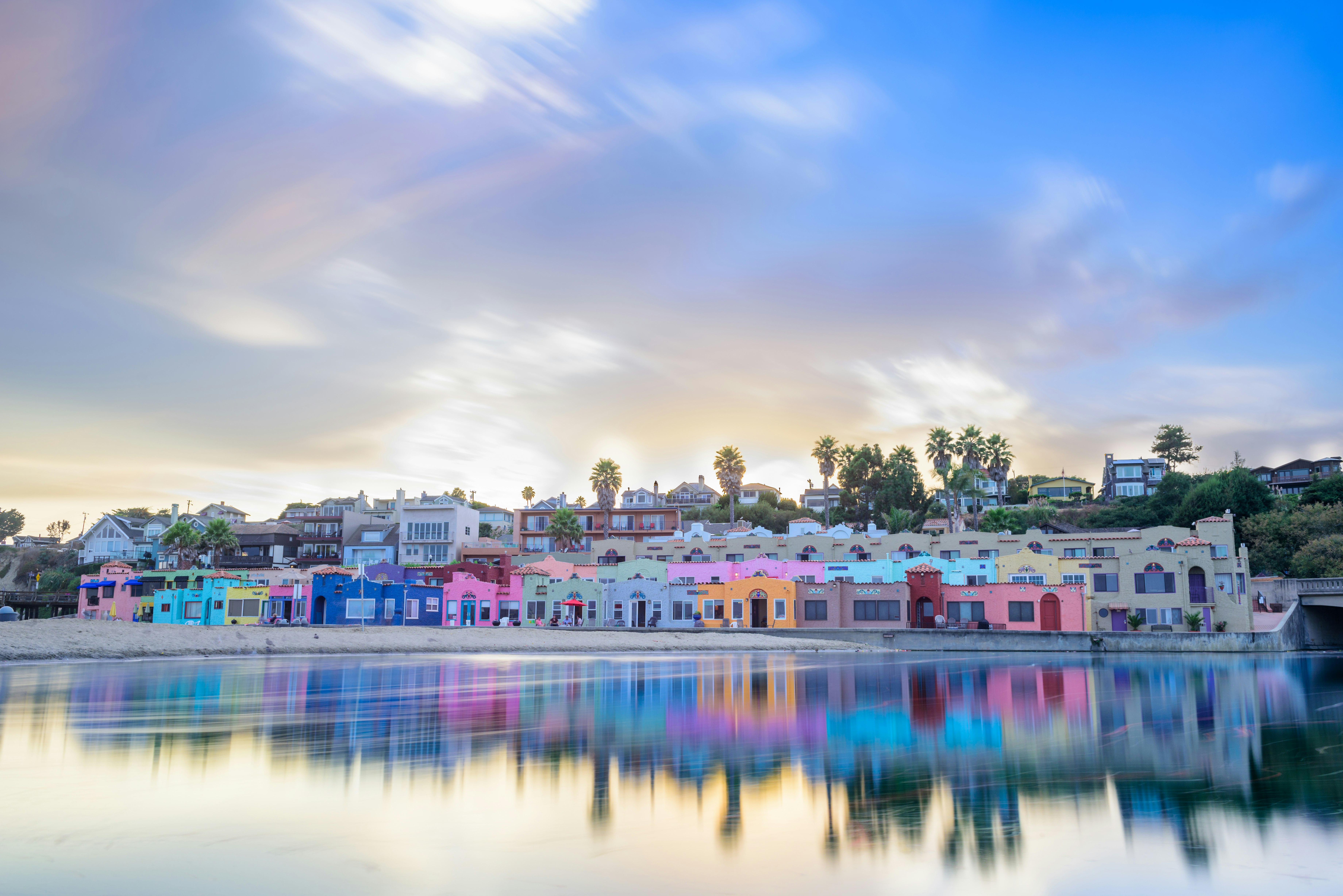 Pastel-colored houses line a pretty bay as the sun starts to go down; California ice cream