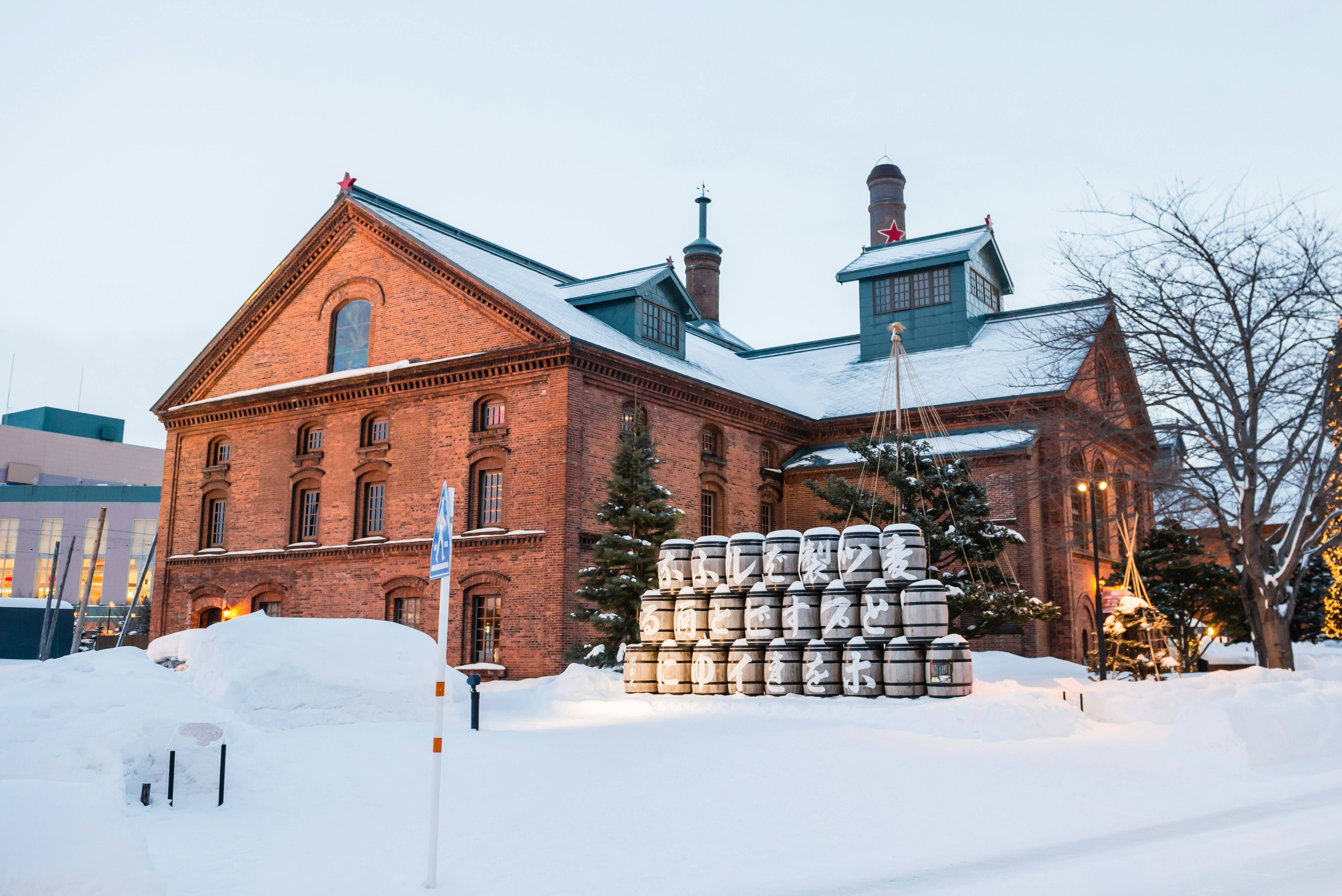 Sapporo Biergarten i Hokkaido, inrymt i en gammal tegelfabrik omgiven av snö, med snödammade ölfat utanför.