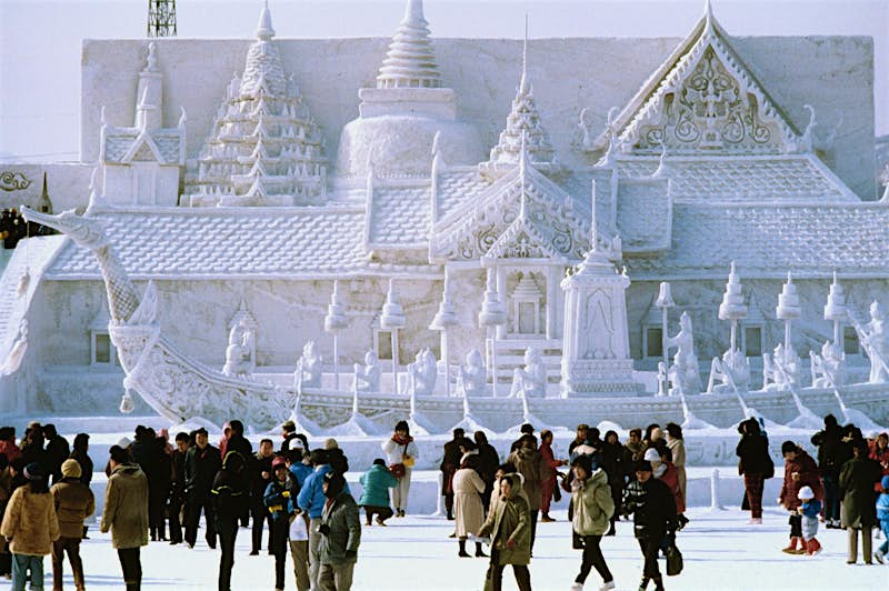 Tourists in front of a snow-sculpted palace at the Sapporo Snow Festival in Hokkaido.