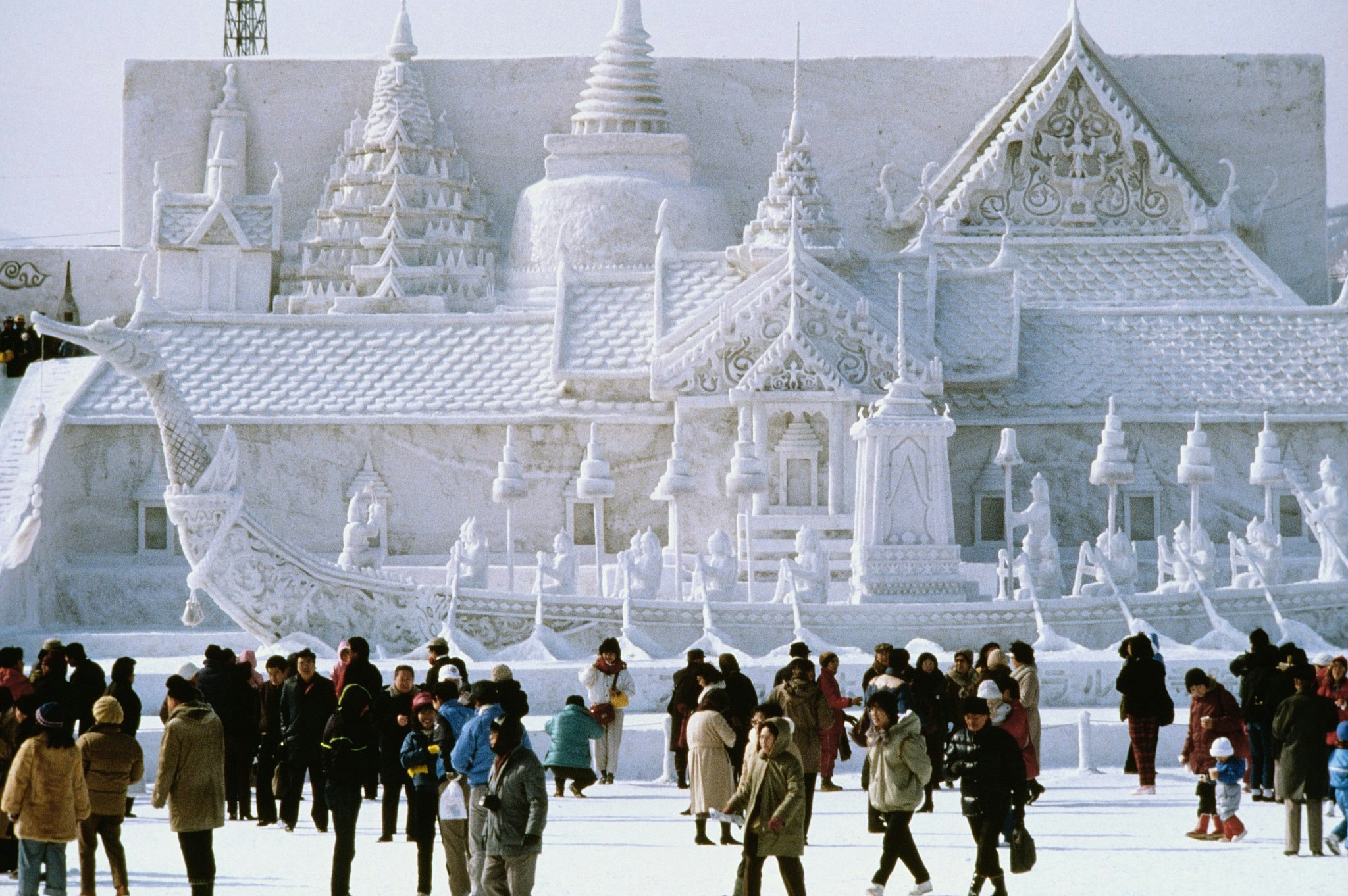 Tourists in front of a snow-sculpted palace at the Sapporo Snow Festival in Hokkaido.