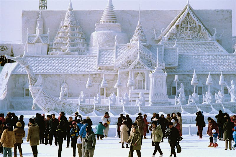 Sapporo Snow Festival Tourists in front of a snow-sculpted palace at the Sapporo Snow Festival in Hokkaido.