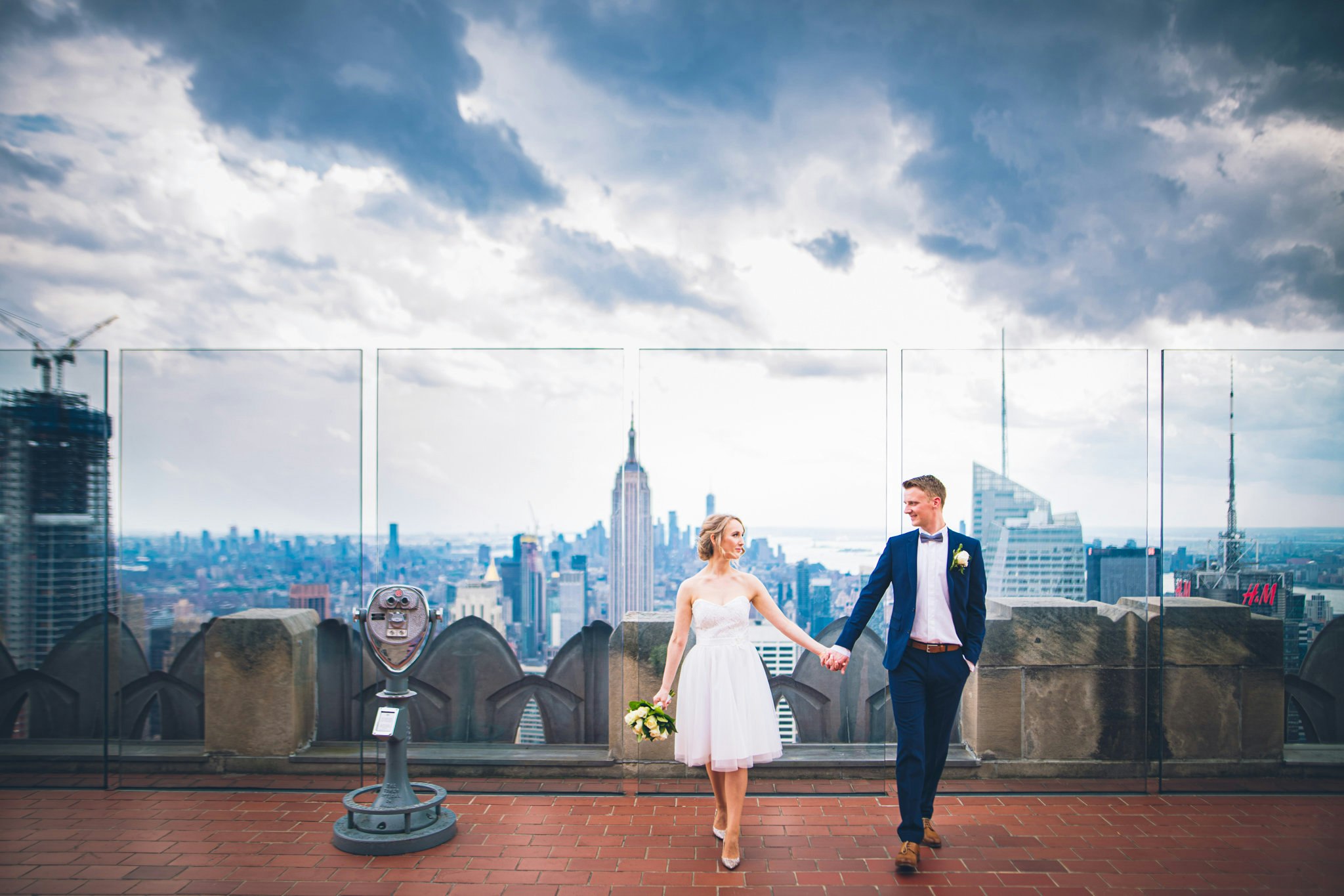 A bride and groom on top of the Empire State Building