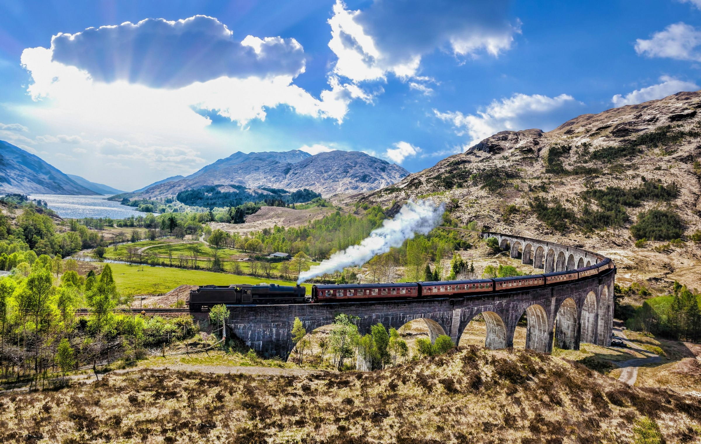 A Jacobite steam train travels over Glenfinnan Railway Viaduct in Scotland.