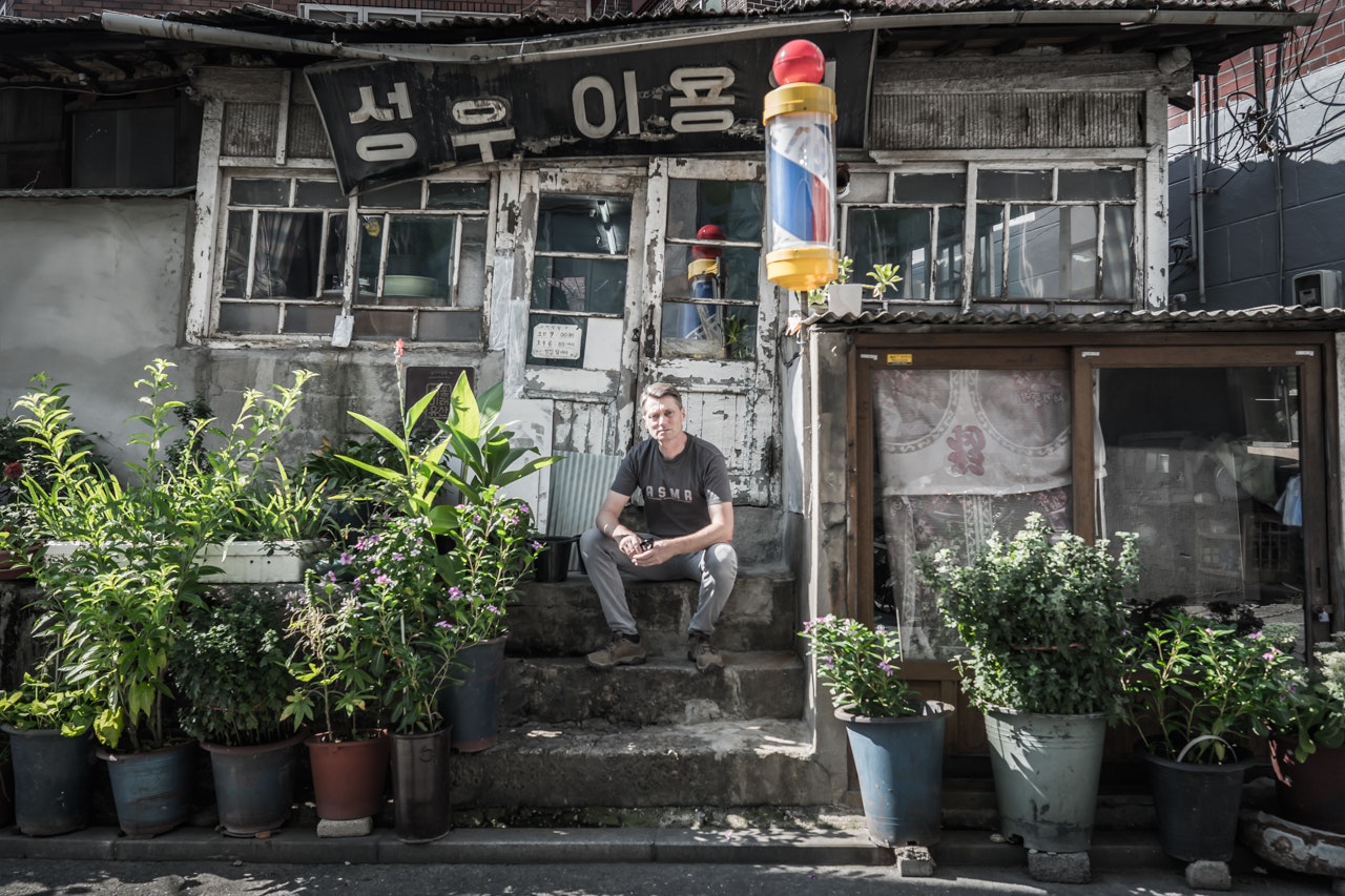 A man sits on steps surrounded by plants in Seongu Seoul South Korea 