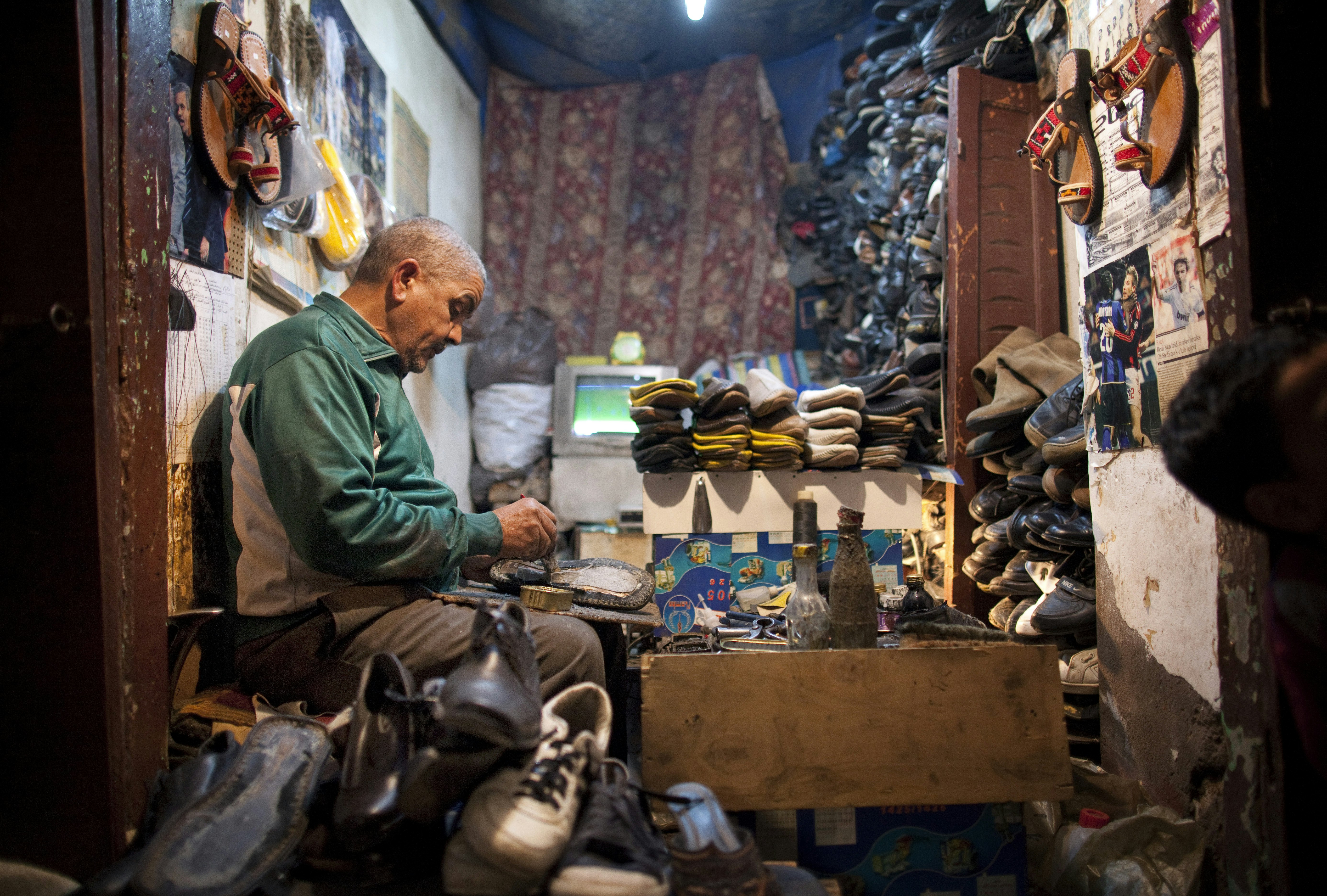 A man works leather shoes in the medina in Marrakesh, Morocco