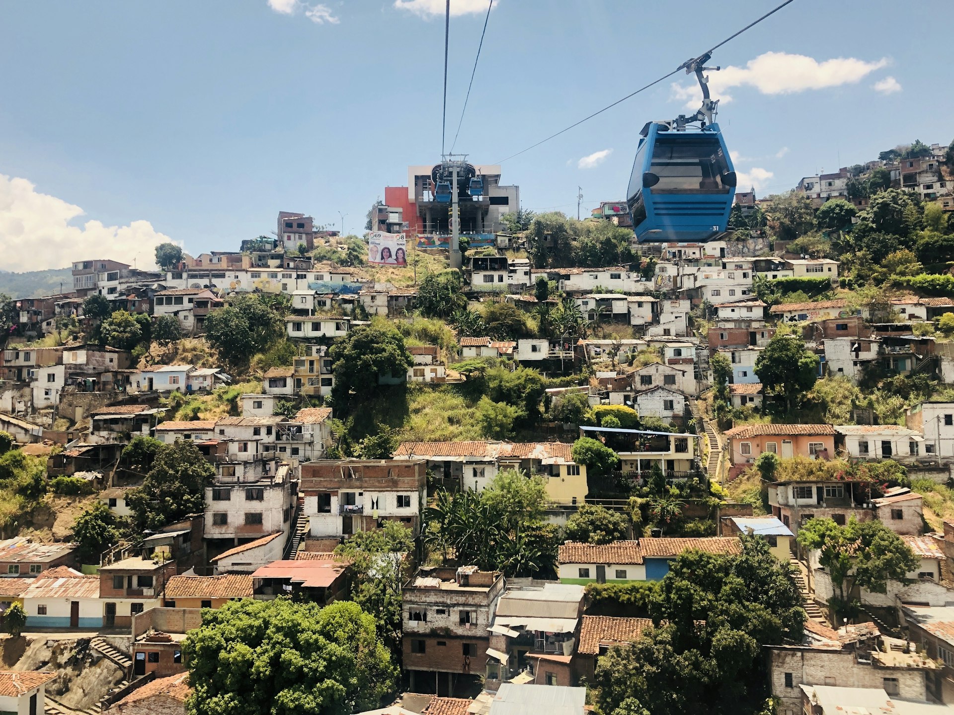Cable cars travel across the town of Siloe on a sunny day; Cali Colombia  