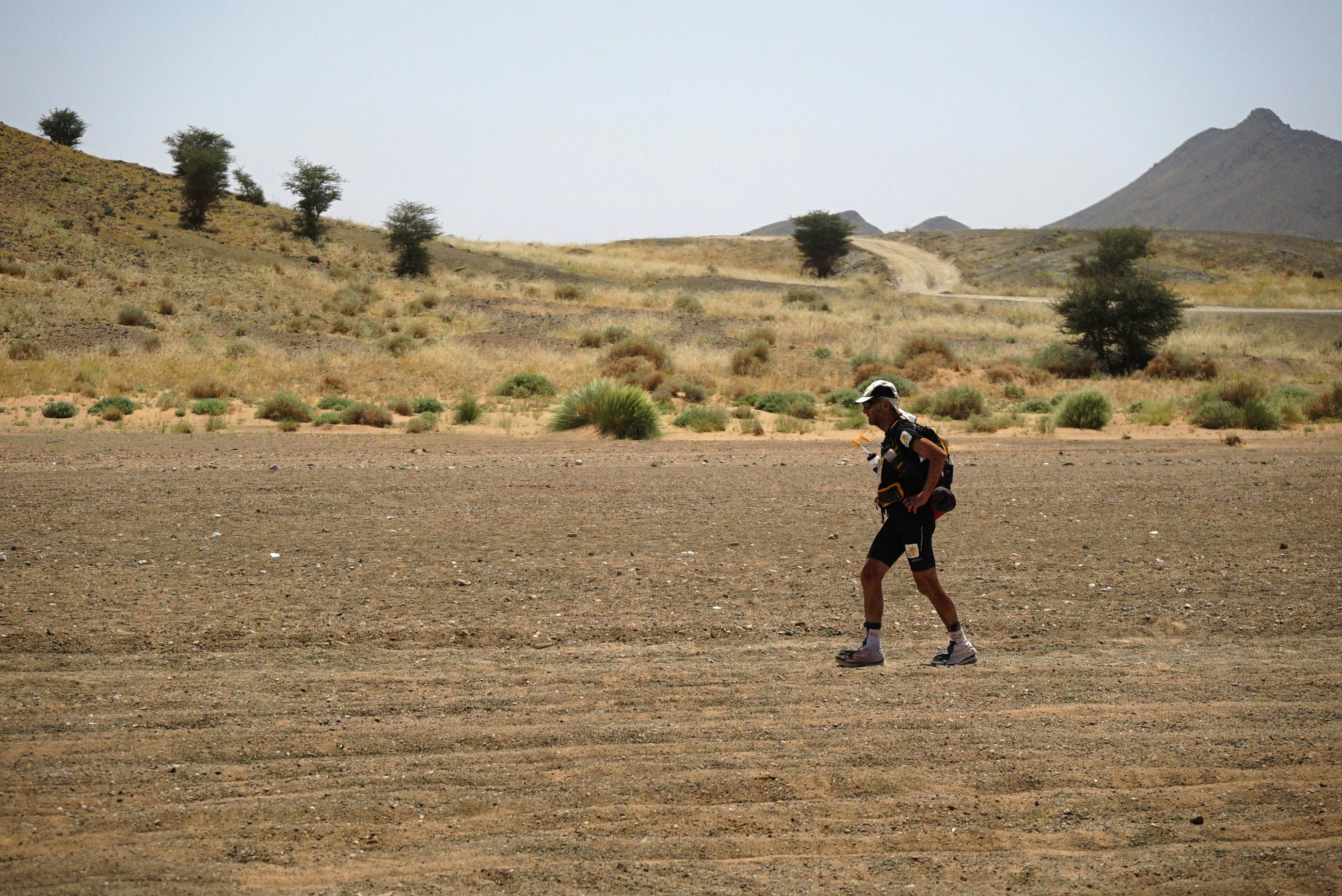 Sir Ran, wearing lycra shorts, a long hat and sunglasses, trods across the rocky sands of Morocco in the Marathon des Sables.