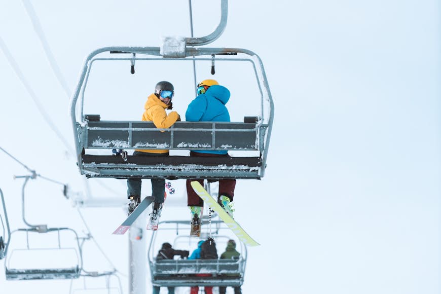 Skiiers look backward as they ride a ski lift up to the top of Mt Bachelor in Bend, Oregon. The mountain is a ski resort in the Cascades range.