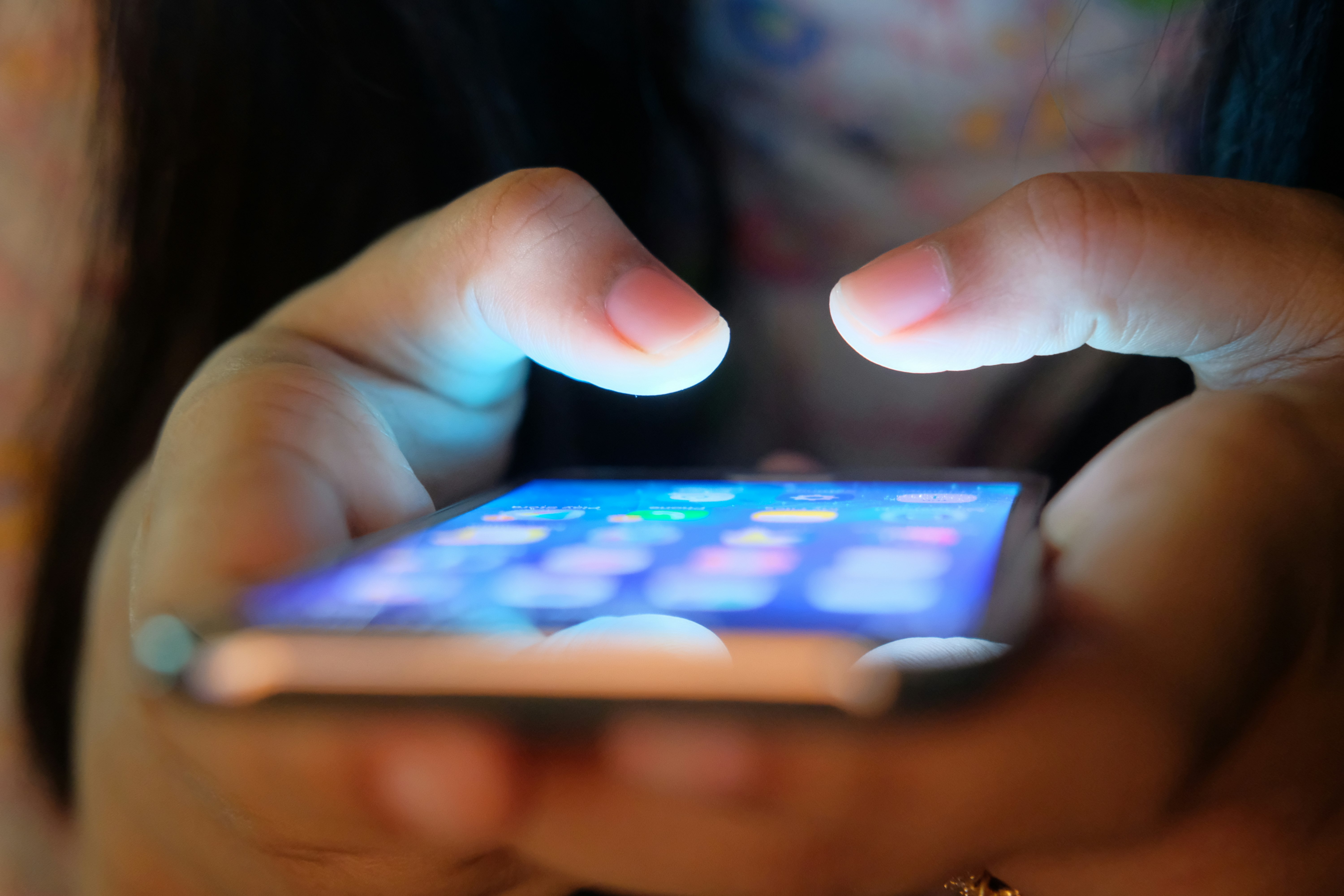 The menu of a smartphone is visible as the phone is held in a hand