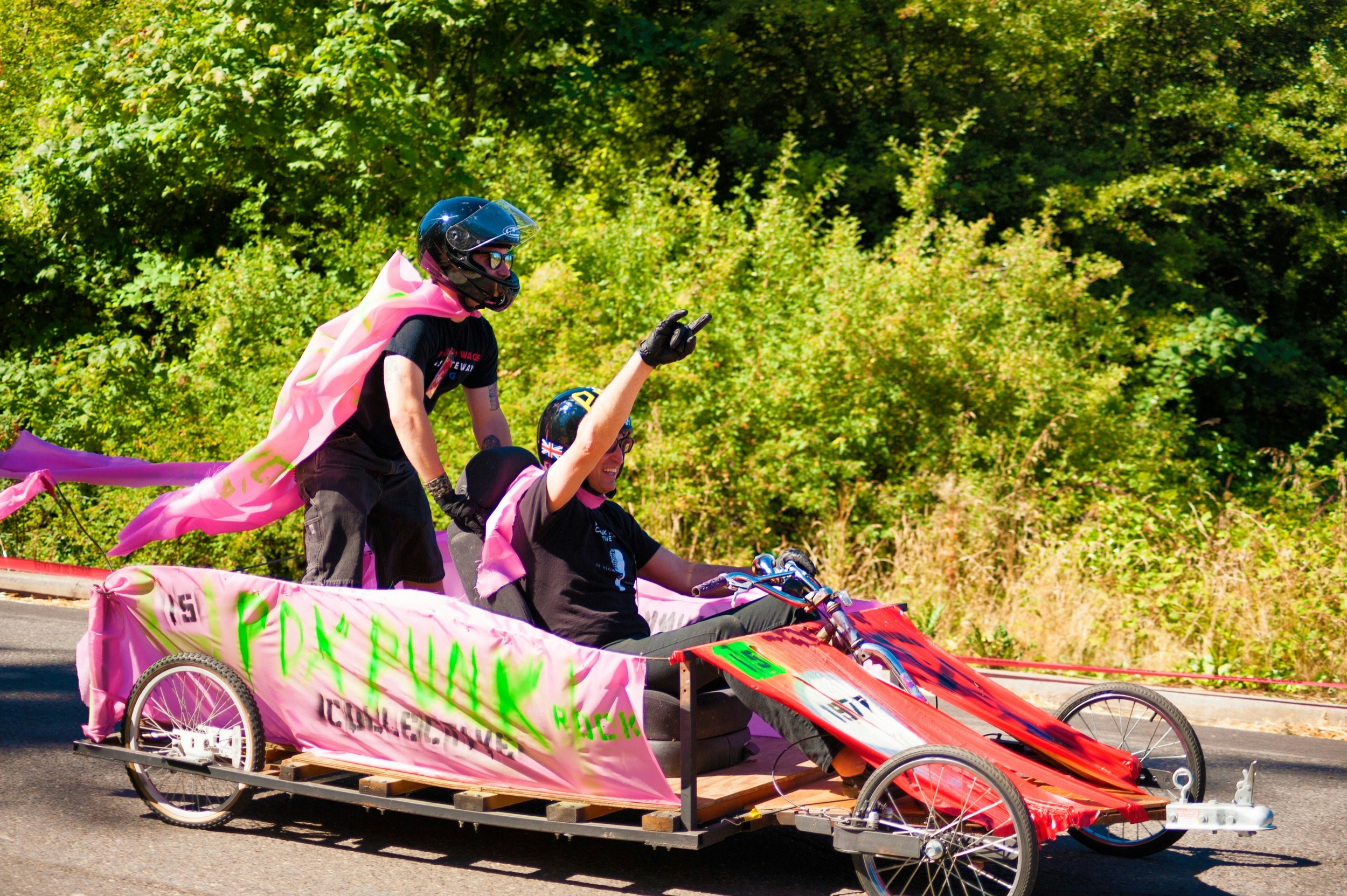 Two men celebrate in a pink soapbox derby racer during a race in Portland, Oregon; Unique sporting events