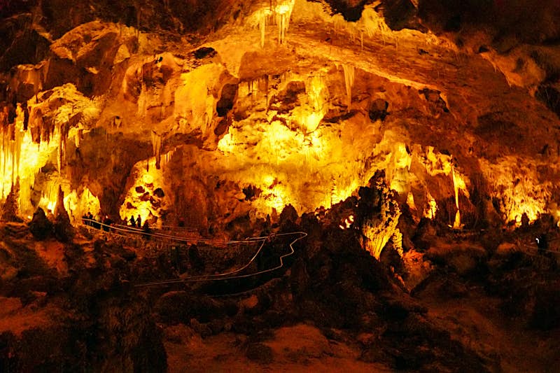 Orange lights illuminate the interior of a cave system