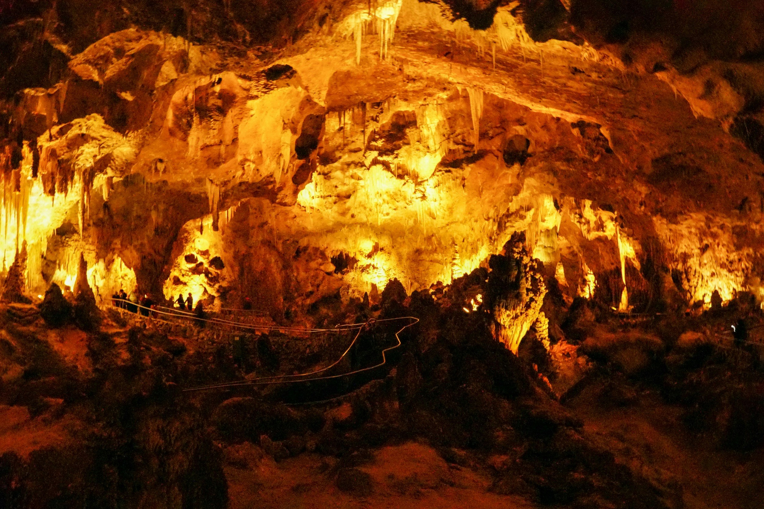 Orange lights illuminate the interior of a cave system