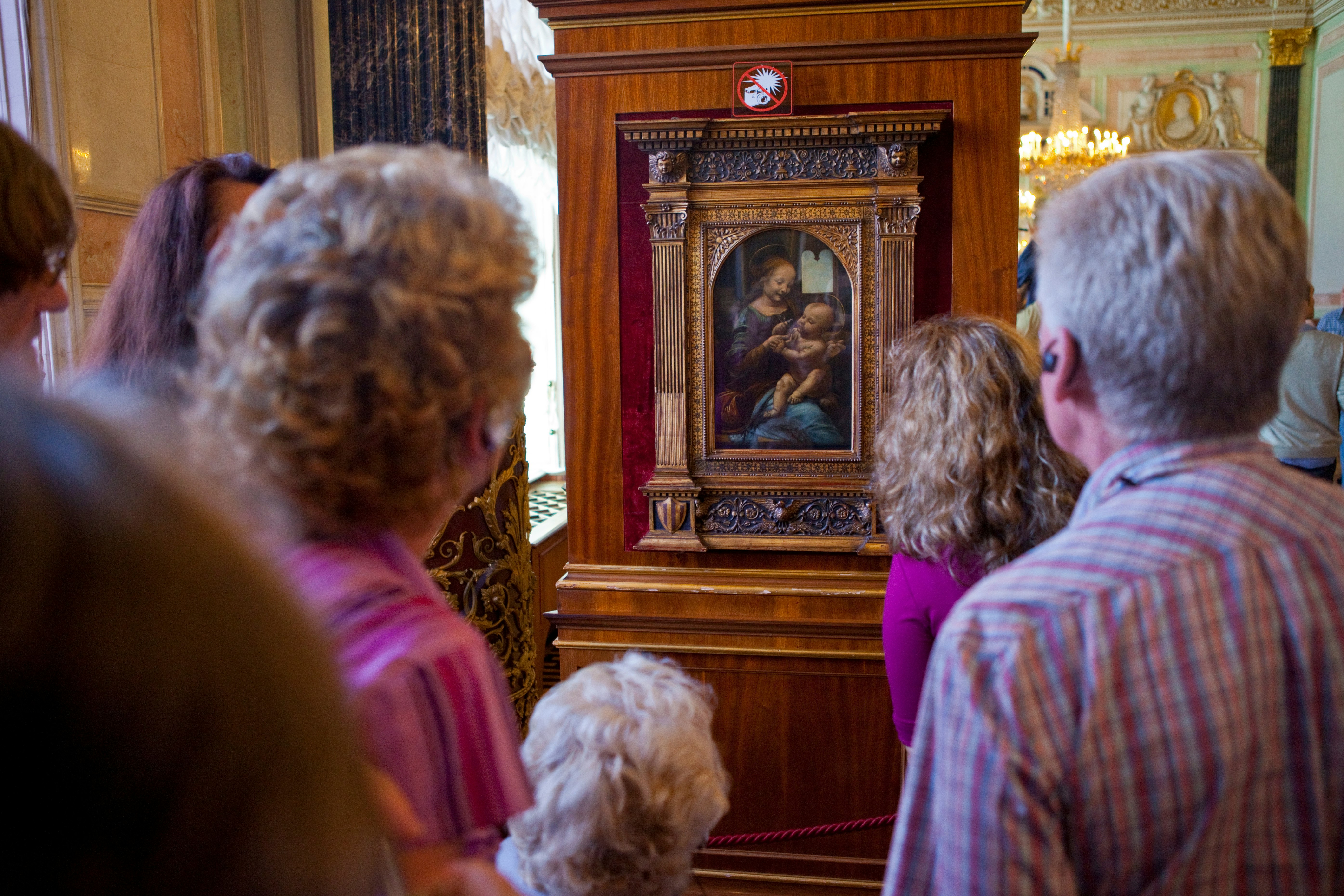 Visitors looking at the painting entitled Madonna and Child with Flowers by Leonardo Da Vinci, at the Hermitage Museum in St. Petersburg