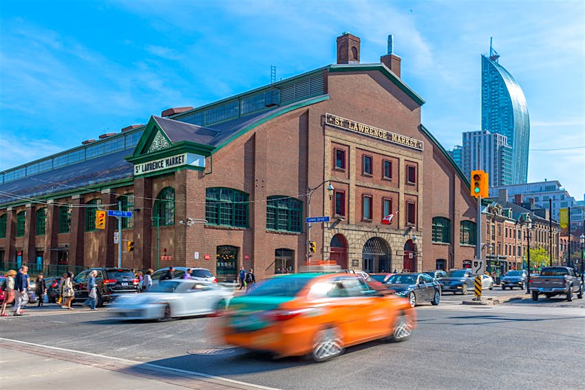 St Lawrence Market during the daytime. A motioned blurred Beck Taxi crosses the scene of the famous place. Free things to do in Toronto