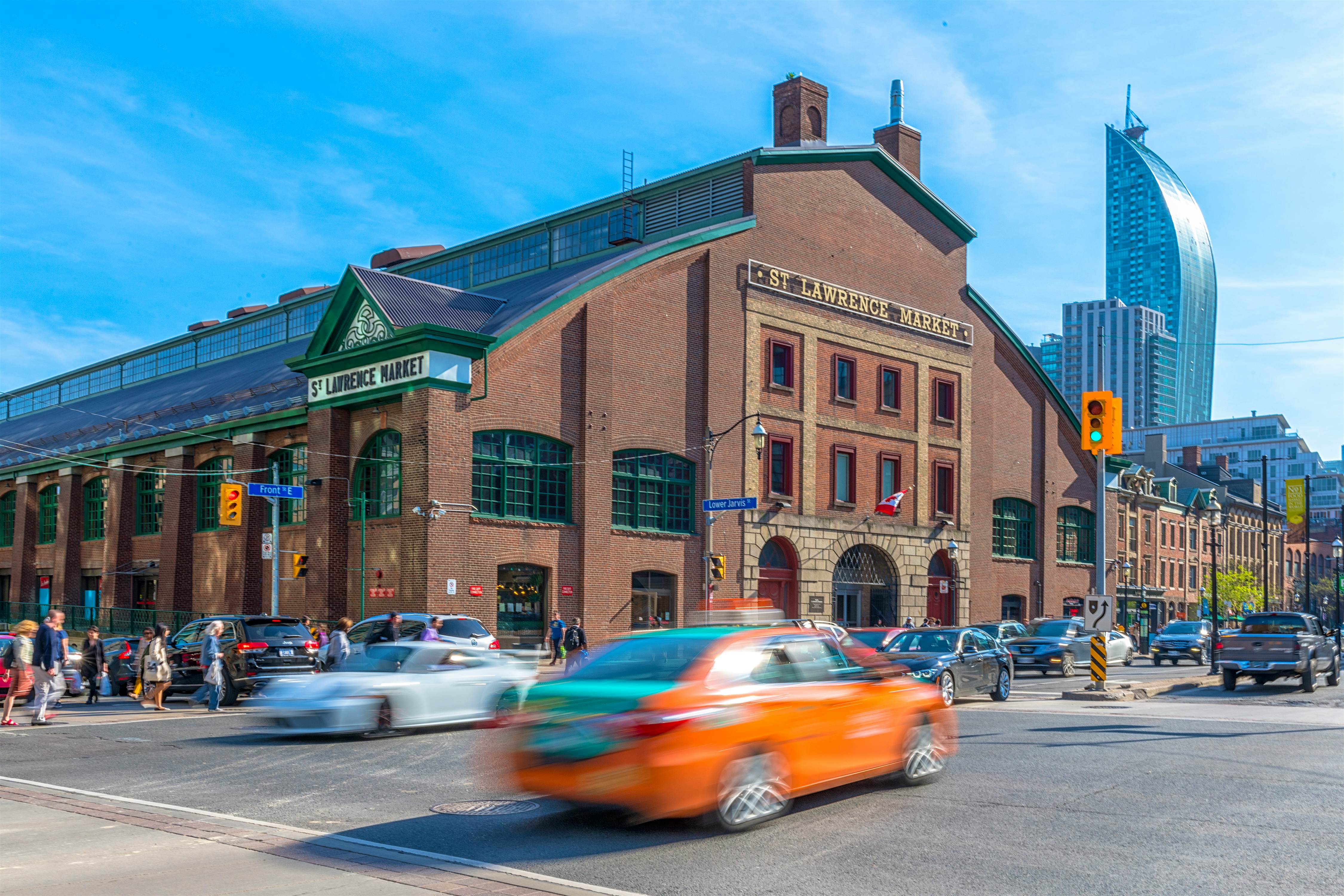 St Lawrence Market during the daytime. A motioned blurred Beck Taxi crosses the scene of the famous place. Free things to do in Toronto